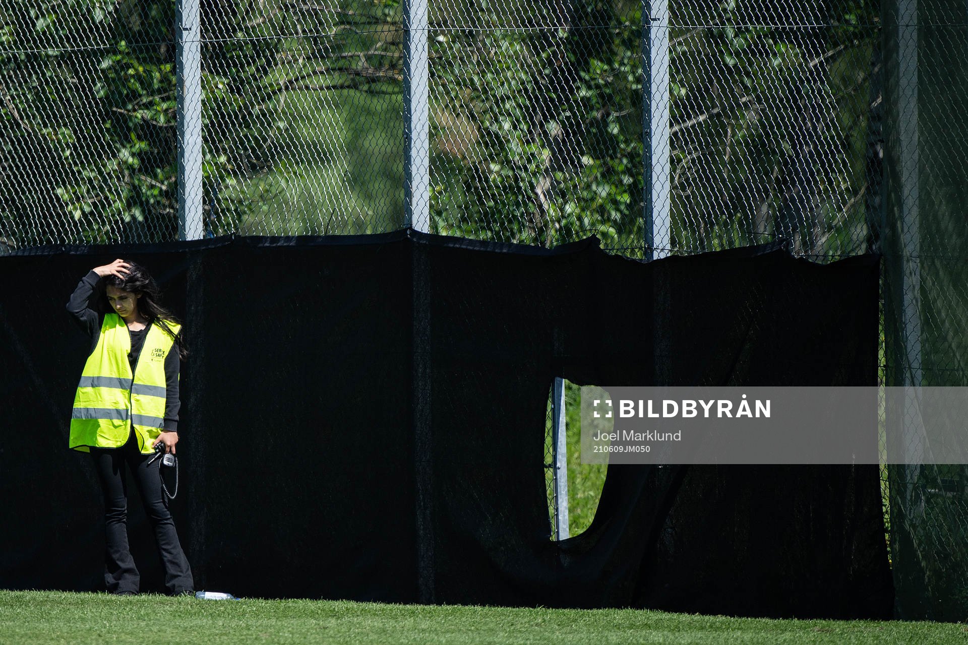 A security guard next a hote in the fence