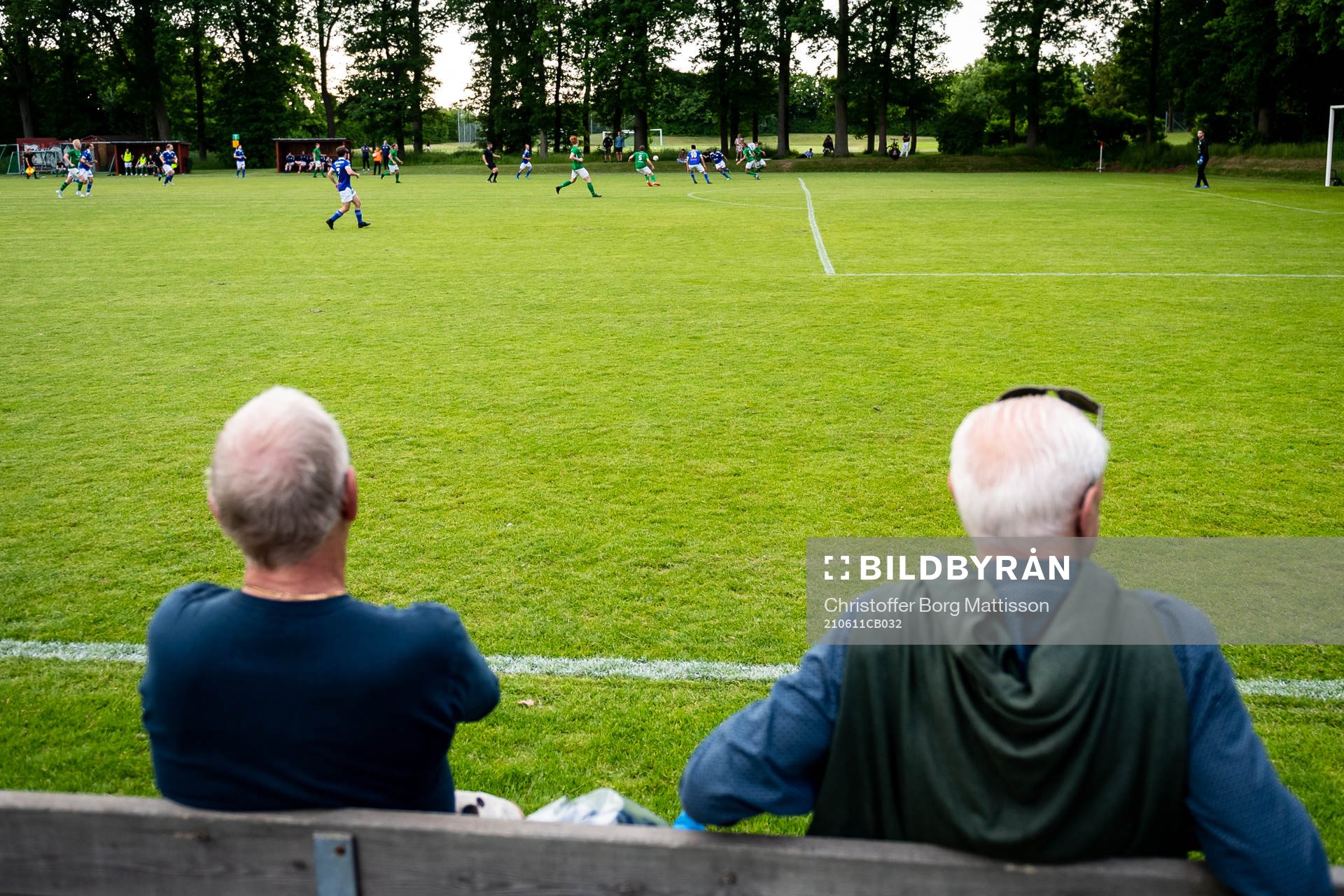 Två herrar sitter på en bänk under fotbollsmatchen i Division 5 Sydvästra Skåne mellan Lunds FF och Lunds SK den 11 juni 2021 i Lund.