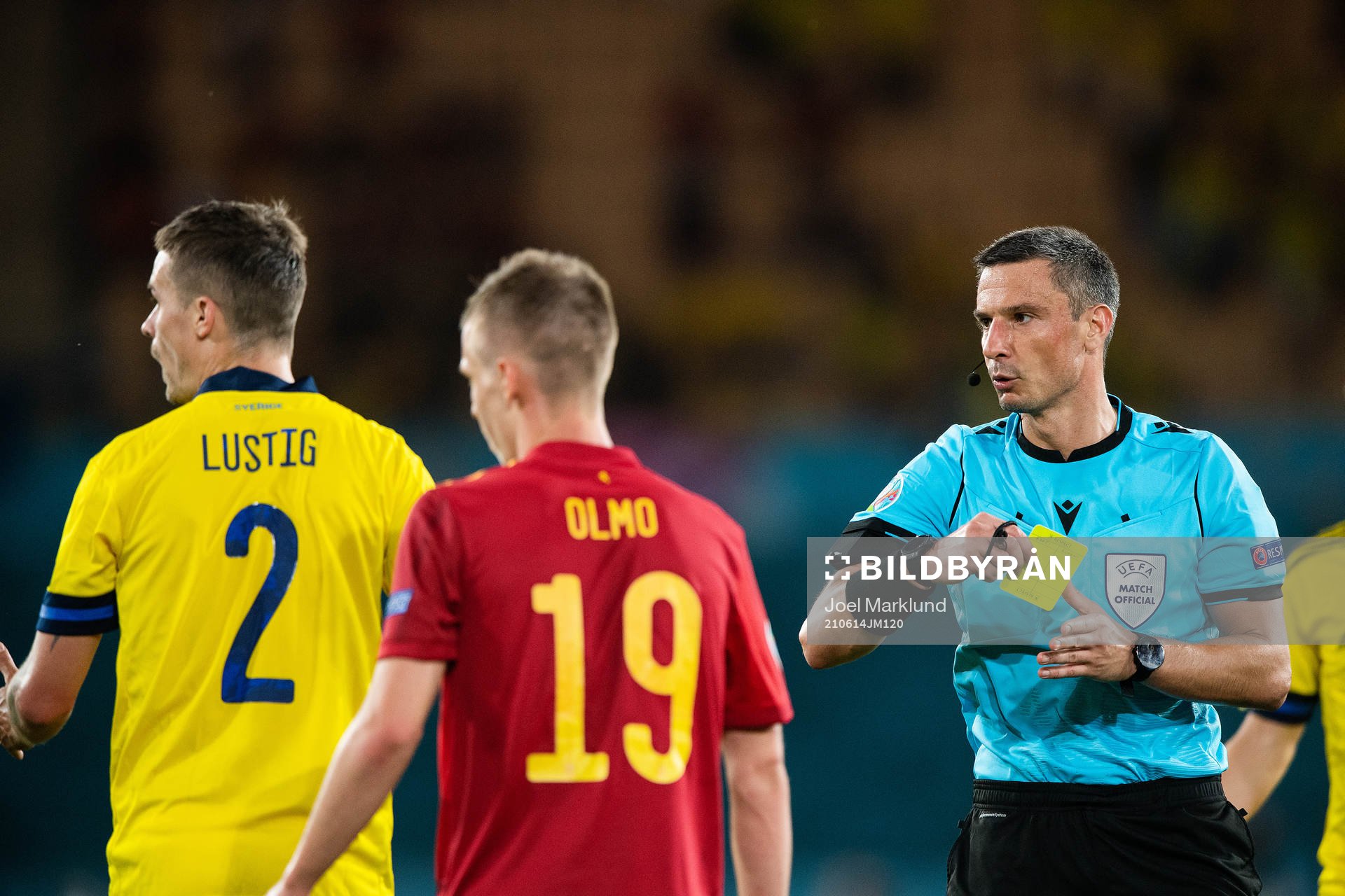 Mikael Lustig of Sweden receives a yellow card from referee