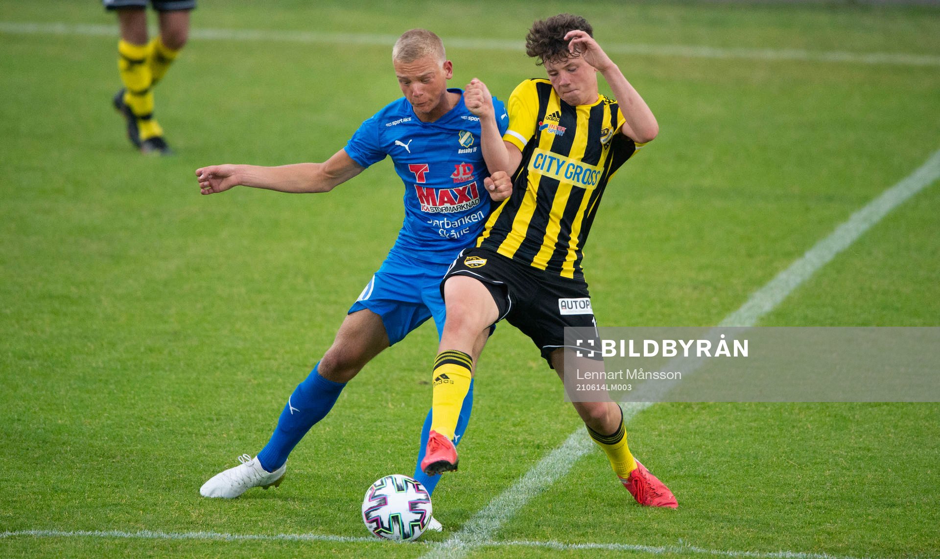 IFK Hässleholms Max Nilsson (född 2005) och Nosabys Olle Kjellman Olfors i matchen i division 2 Södra Götaland mellan IFK Hässleholm och Nosaby IF i Hässleholm 14 juni 2021.