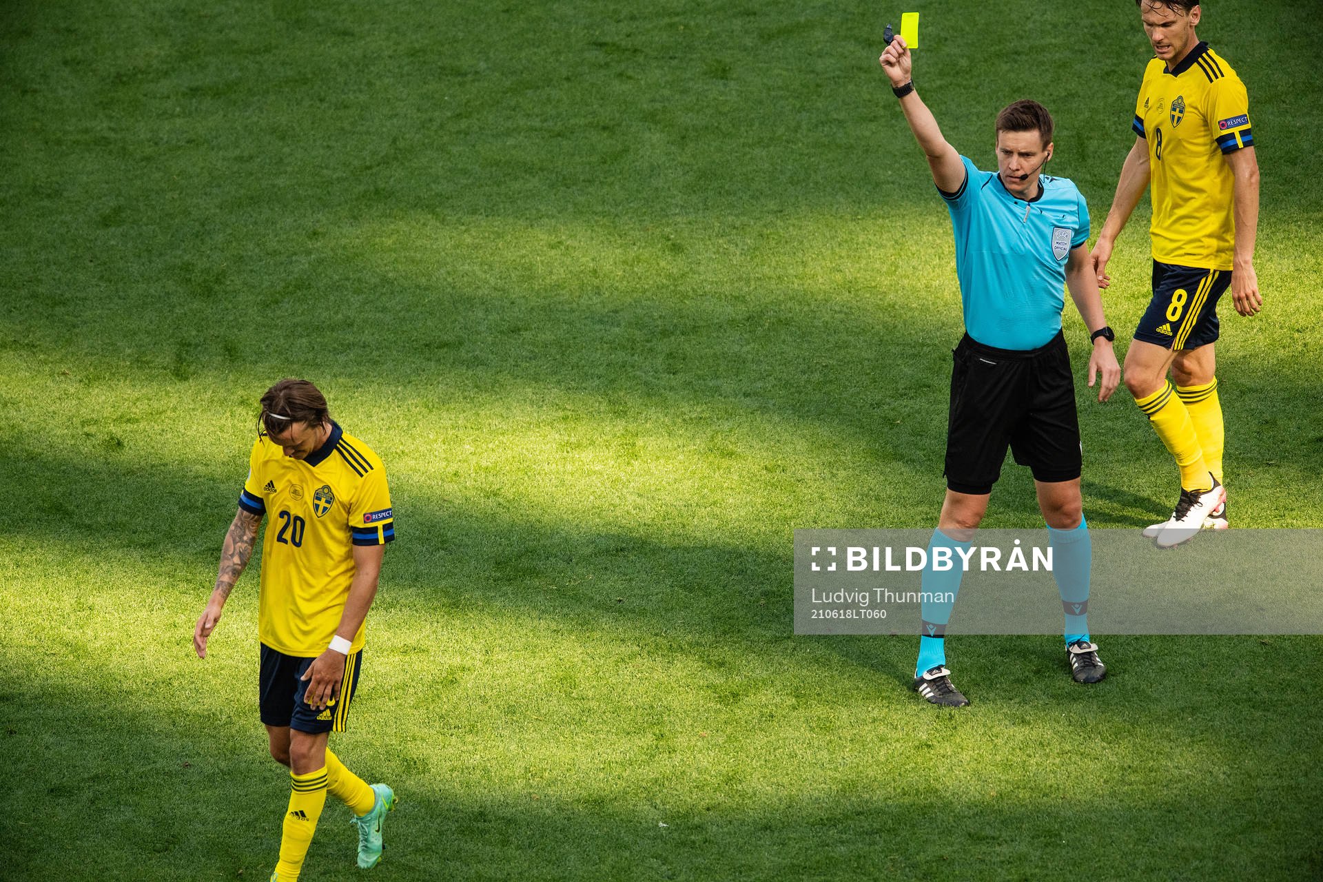 Kristoffer Olsson of Sweden receives a yellow card from