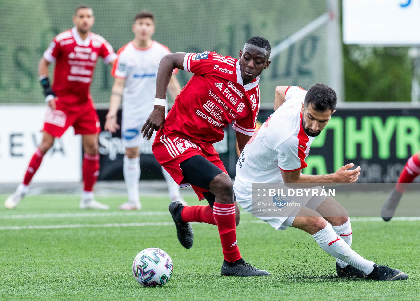 Piteås Modoumatarr Mbye och Assyriskas Gabriel Aphrem under fotbollsmatchen i Division 1 norra mellan Piteå IF och Assyriska den 19 juni 2021 i Piteå.