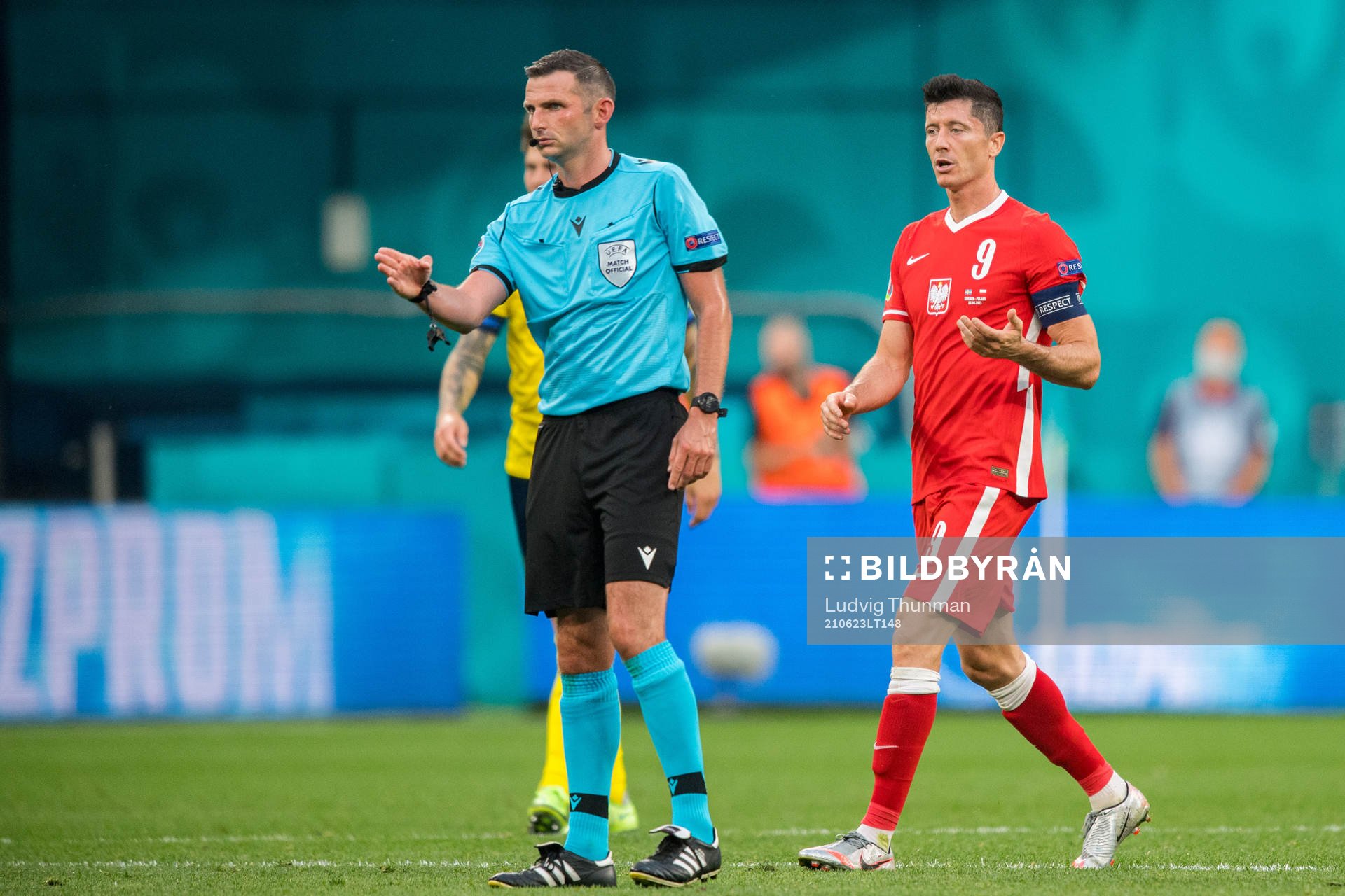 Referee Michael Oliver and Robert Lewandowski of Poland