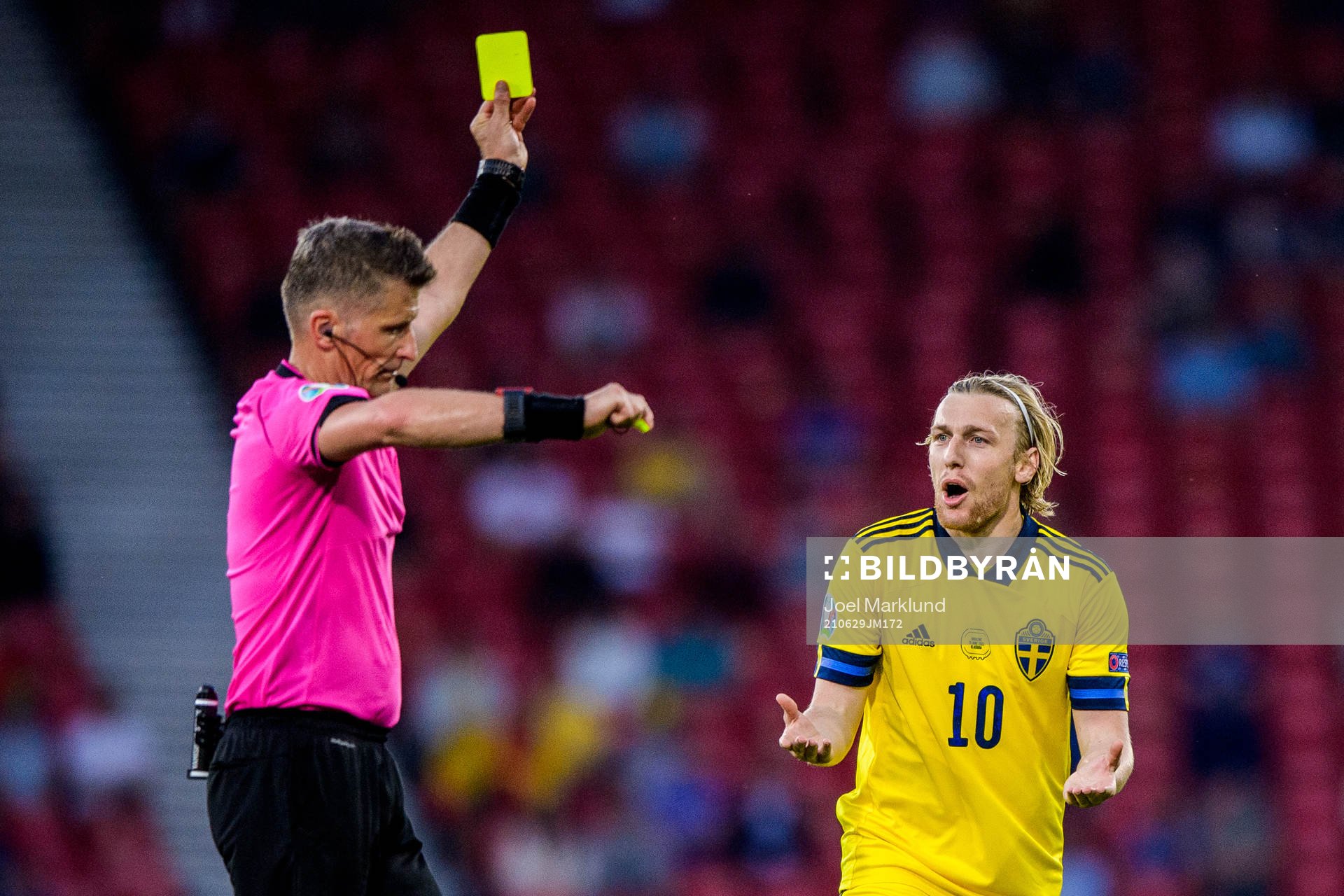 referee Daniele Orsato shows a yellow card to Emil Forsberg