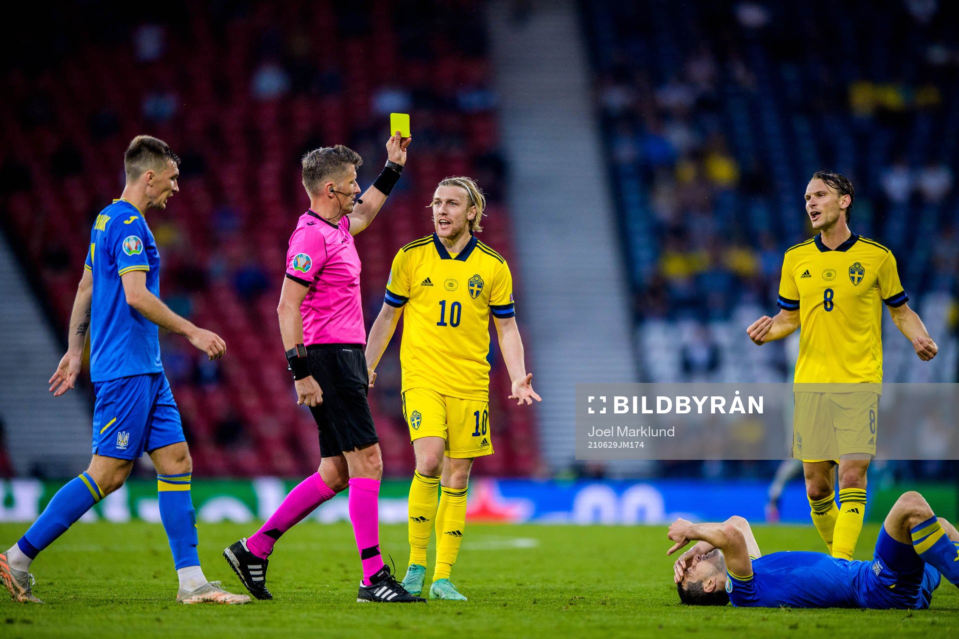 referee Daniele Orsato shows a yellow card to Emil Forsberg