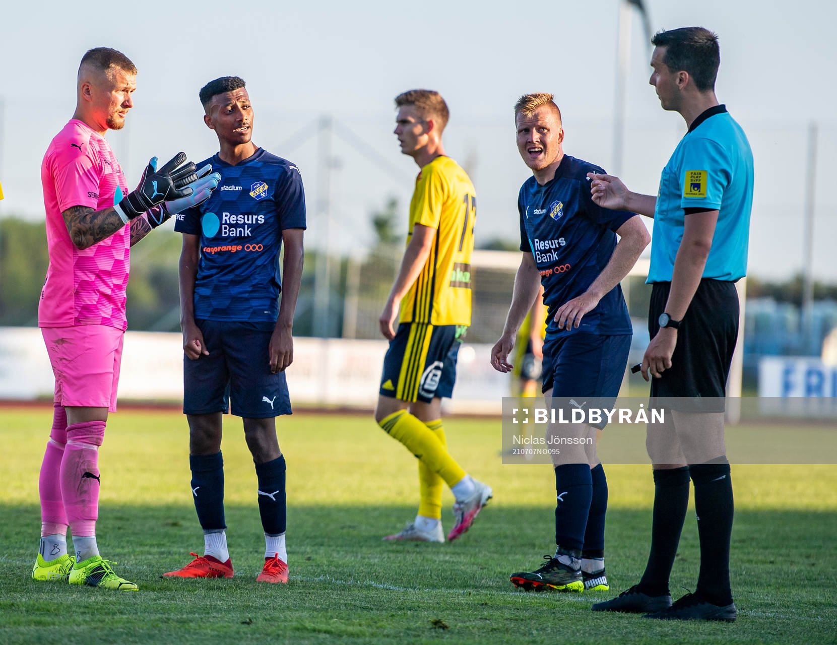 Eskilsminnes Målvakt Pontus Löfvenmark, Josef Getachew och Victor Wahlgren i diskussion med domare Ivan Prgomet under fotbollsmatchen i Division 2 Västra Götaland mellan Ängelholm och Eskilsminne den 7 juli 2021 i Ängelholm.