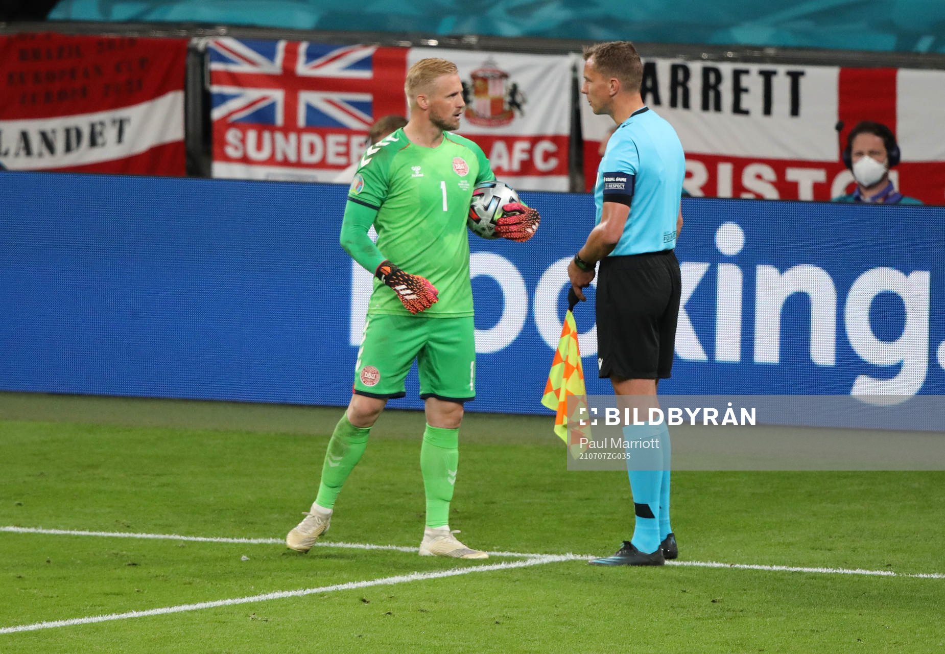 Goalkeeper Kasper Schmeichel speaks to the assistant referee