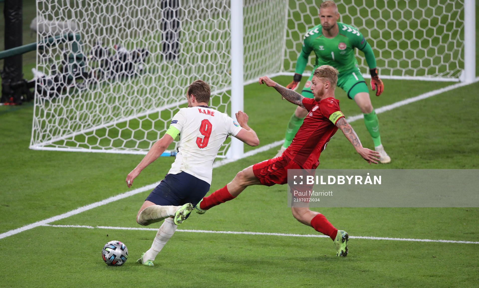 Harry Kane  of England and Simon Kjær of Denmark