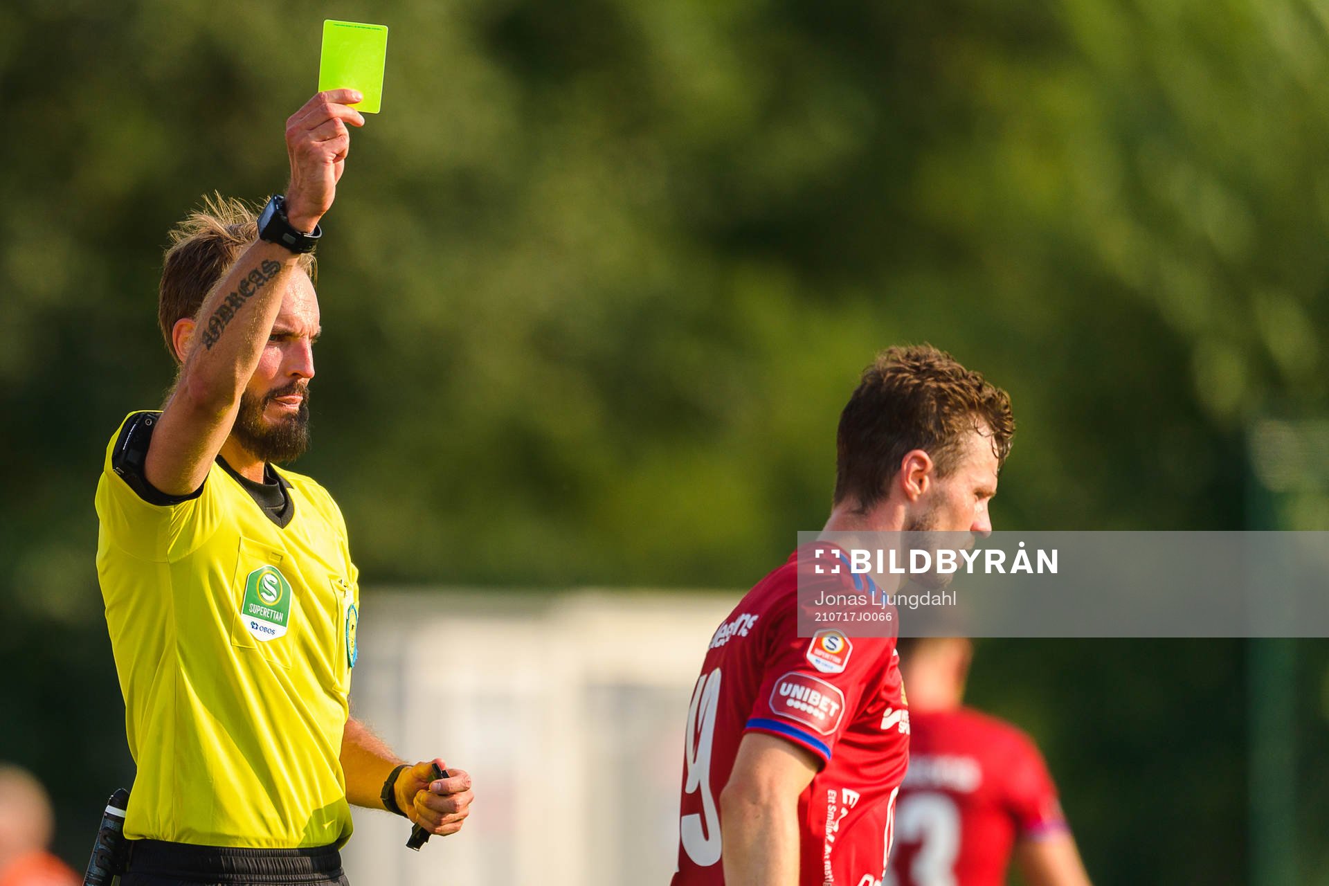 Domare Andreas Dufva Johansson delar ut ett gult kort till