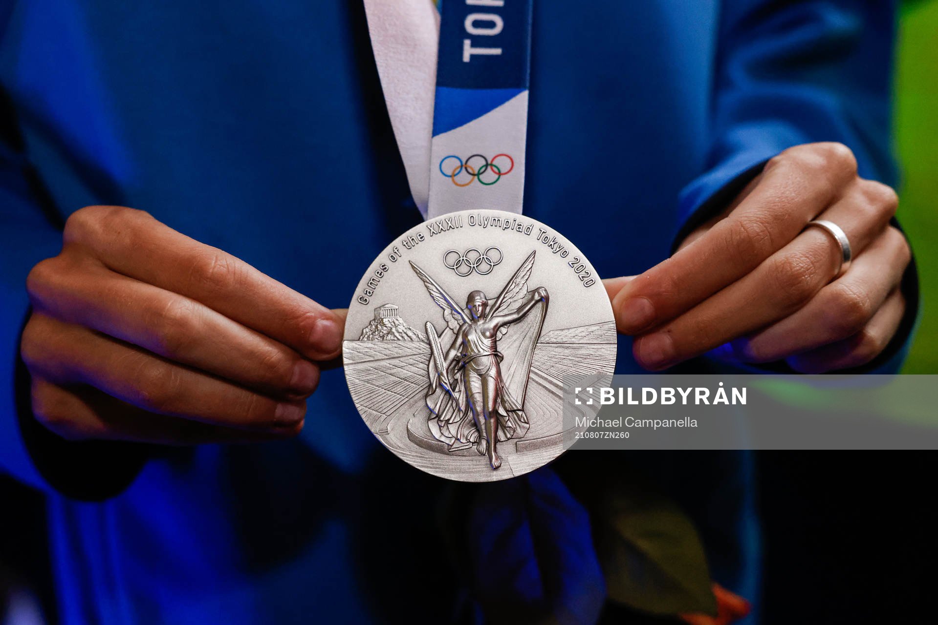 An olympic silver medal is shown at a press meet
