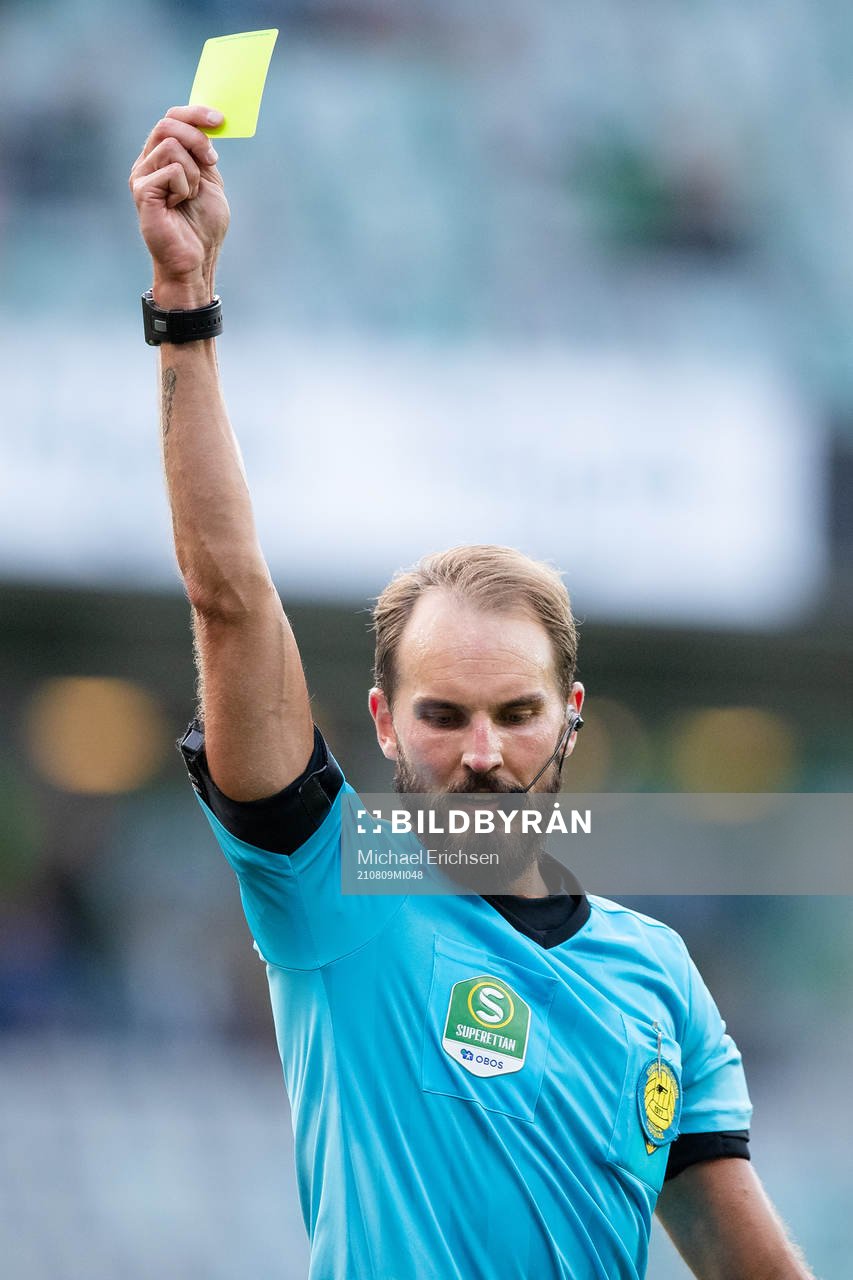 Domare Andreas Dufva-Johansson delar ut ett gult kort