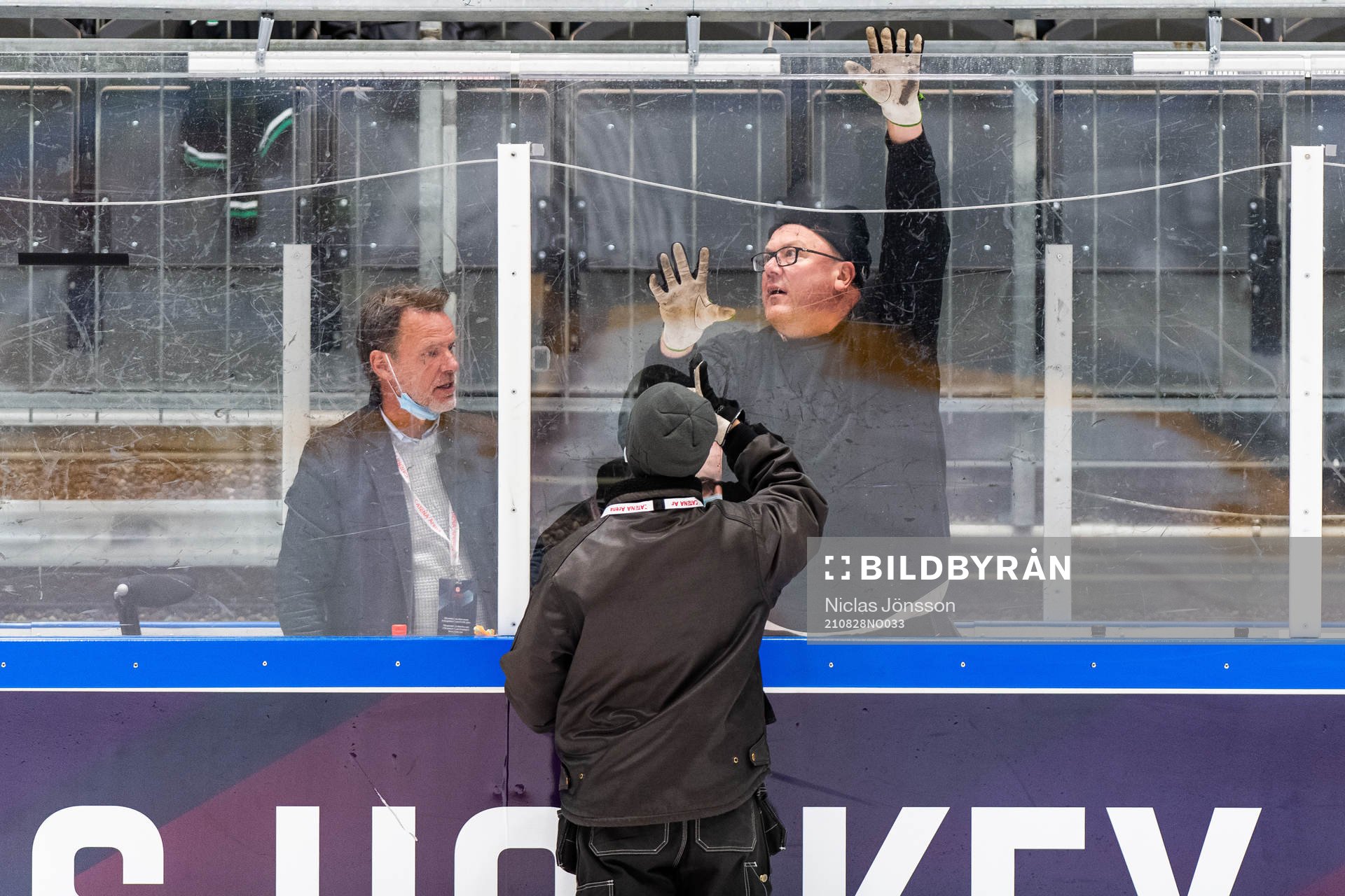 An attendant replaces a piece of plexiglass