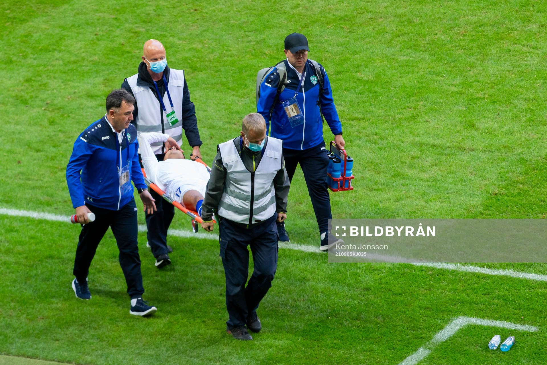 Farrukh Ikromov of Uzbekistan is carried off the pitch