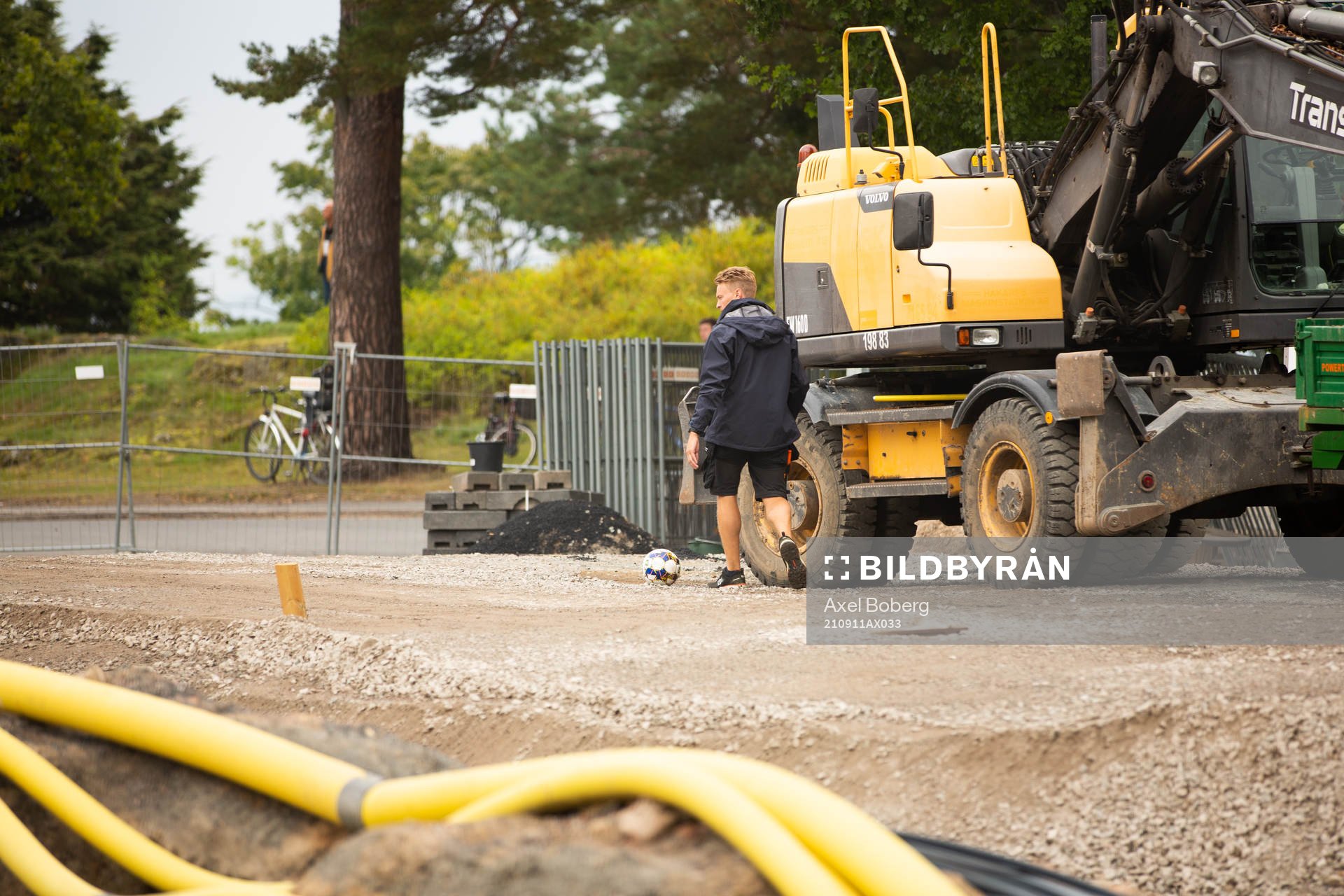 En funktionär hämtar en boll som sparkats över nätet