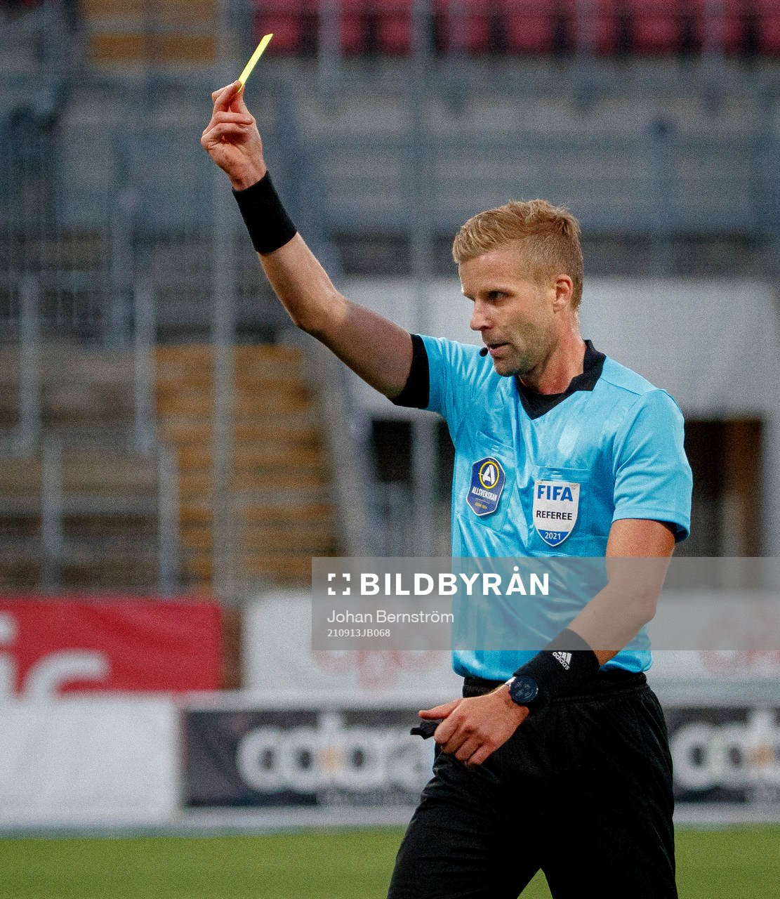 Domare Glenn Nyberg delar ut ett gult kort