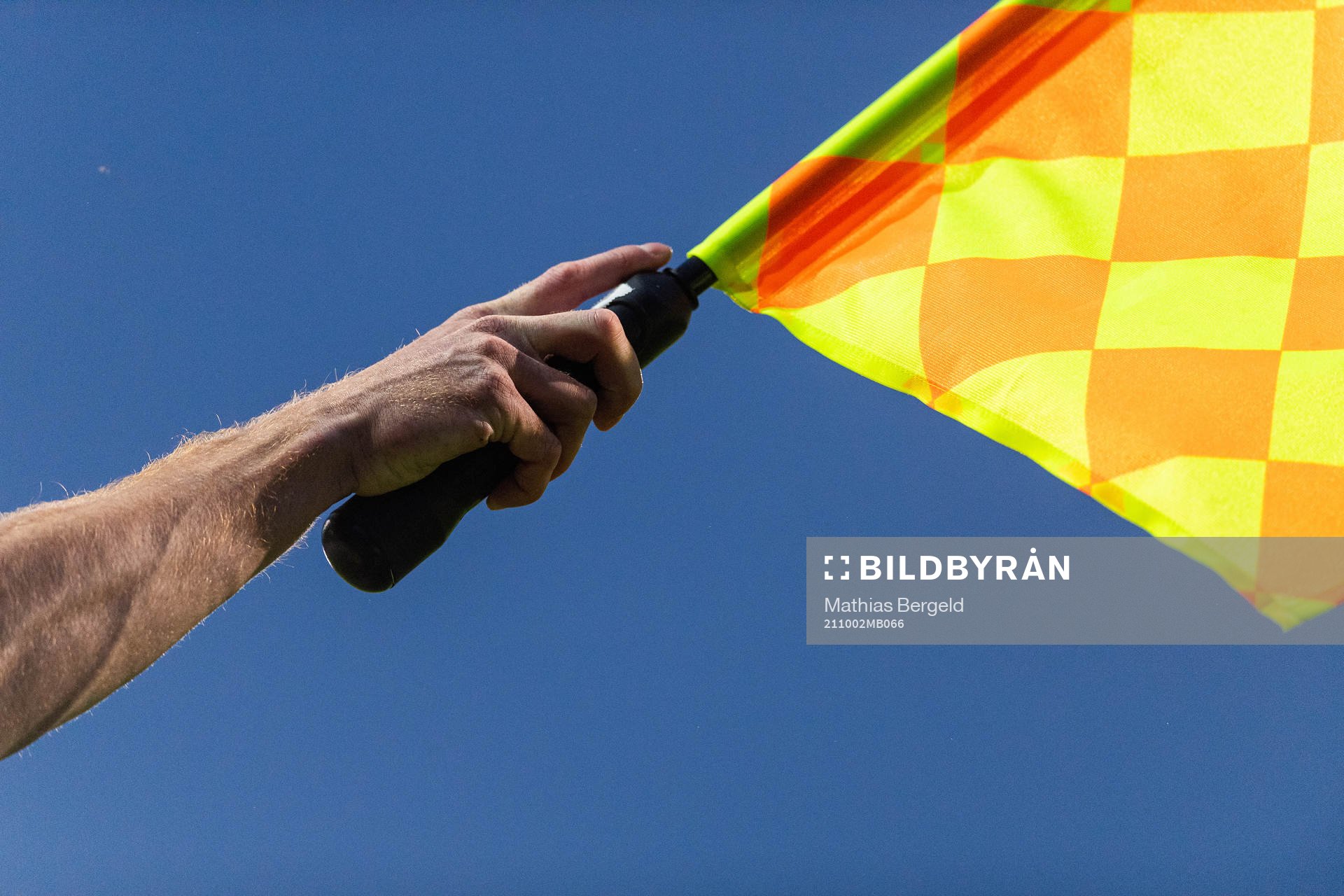 En assisterande domares hand håller en flagga