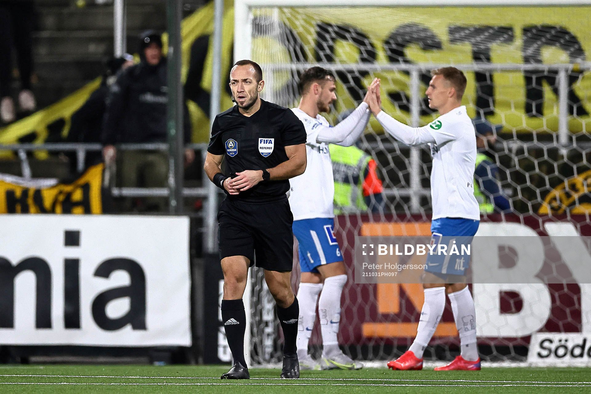 Domare Kaspar Sjöberg medan Linus Wahlqvist och Marco Lund Nielsen jublar  under fotbollsmatchen i Allsvenskan mellan IFK Norrköping och Elfsborg den 31 oktober 2021 i Norrköping. 