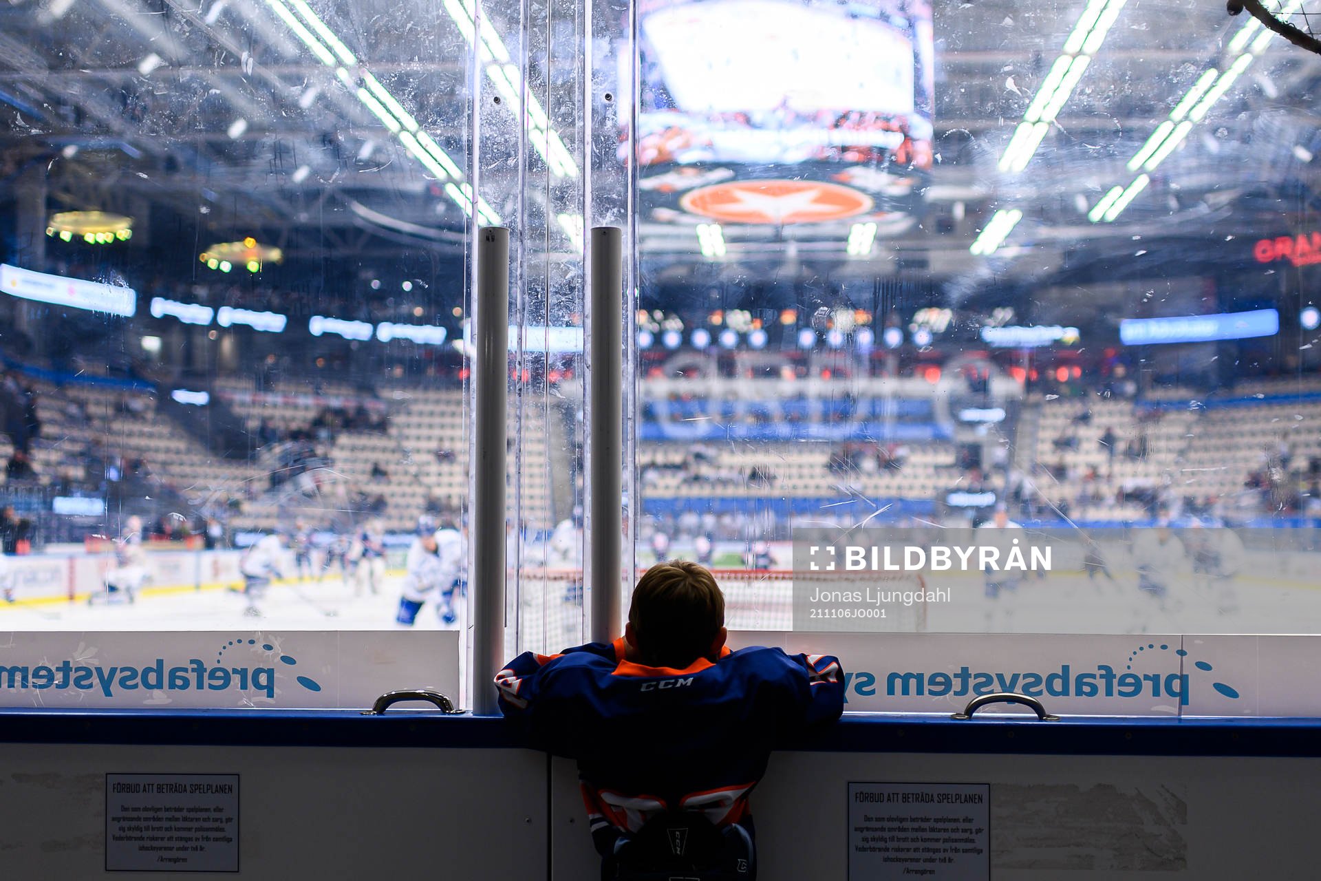 En fanbärare tittar på värmningen före ishockeymatchen
