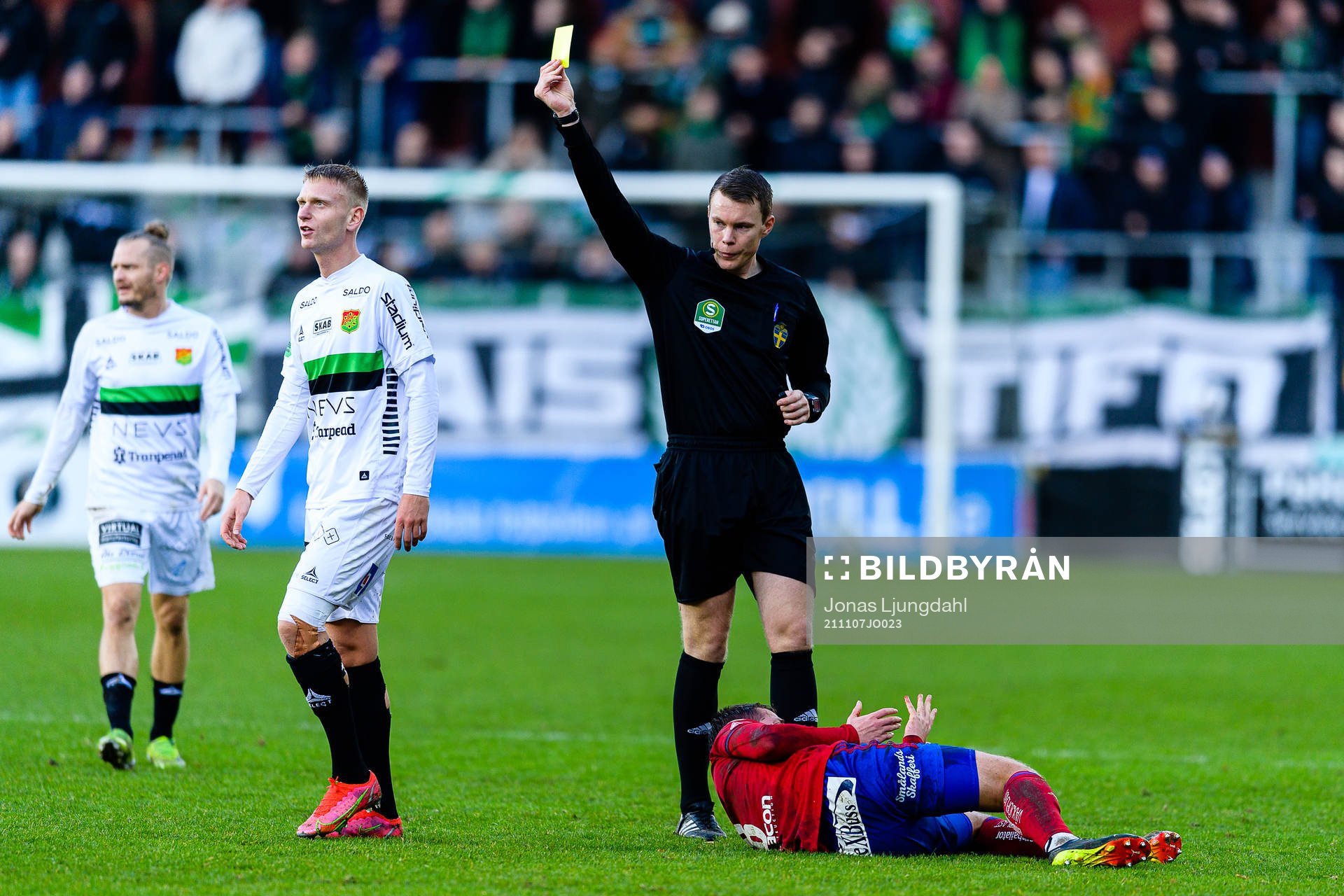 Domare Oscar Johnson delar ut ett gult kort till GAIS