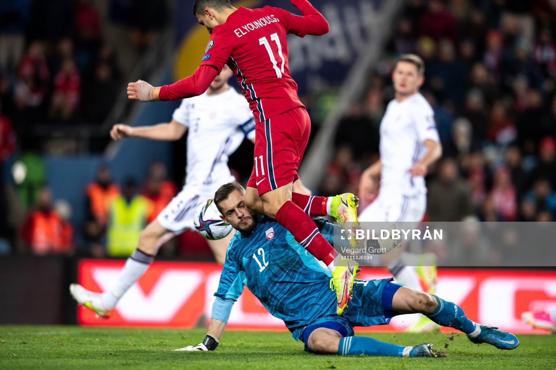 Mohamed Elyounoussi of Norway hits goalkeeper Roberts Ozols