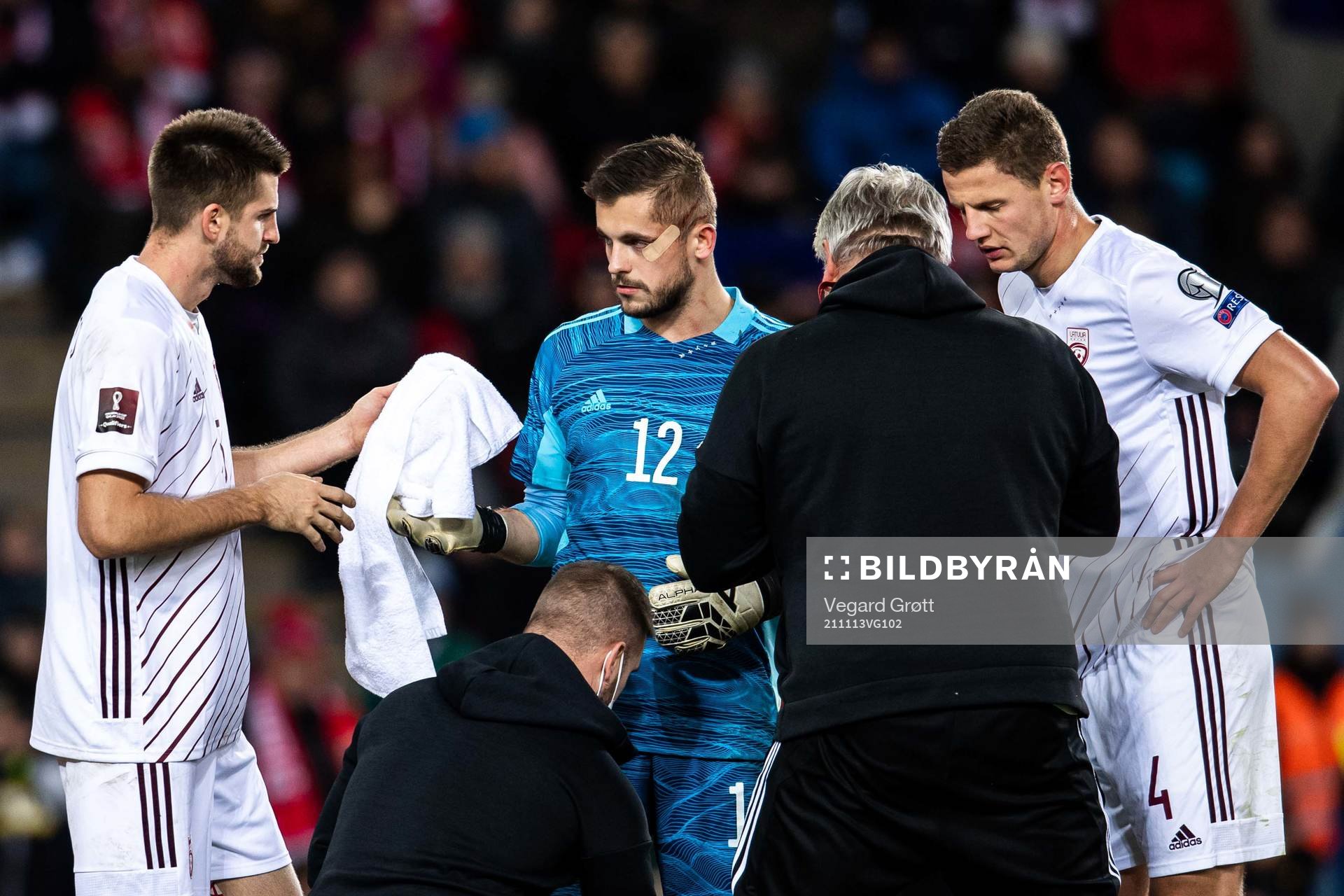 Goalkeeper Roberts Ozols of Latvia receives medical