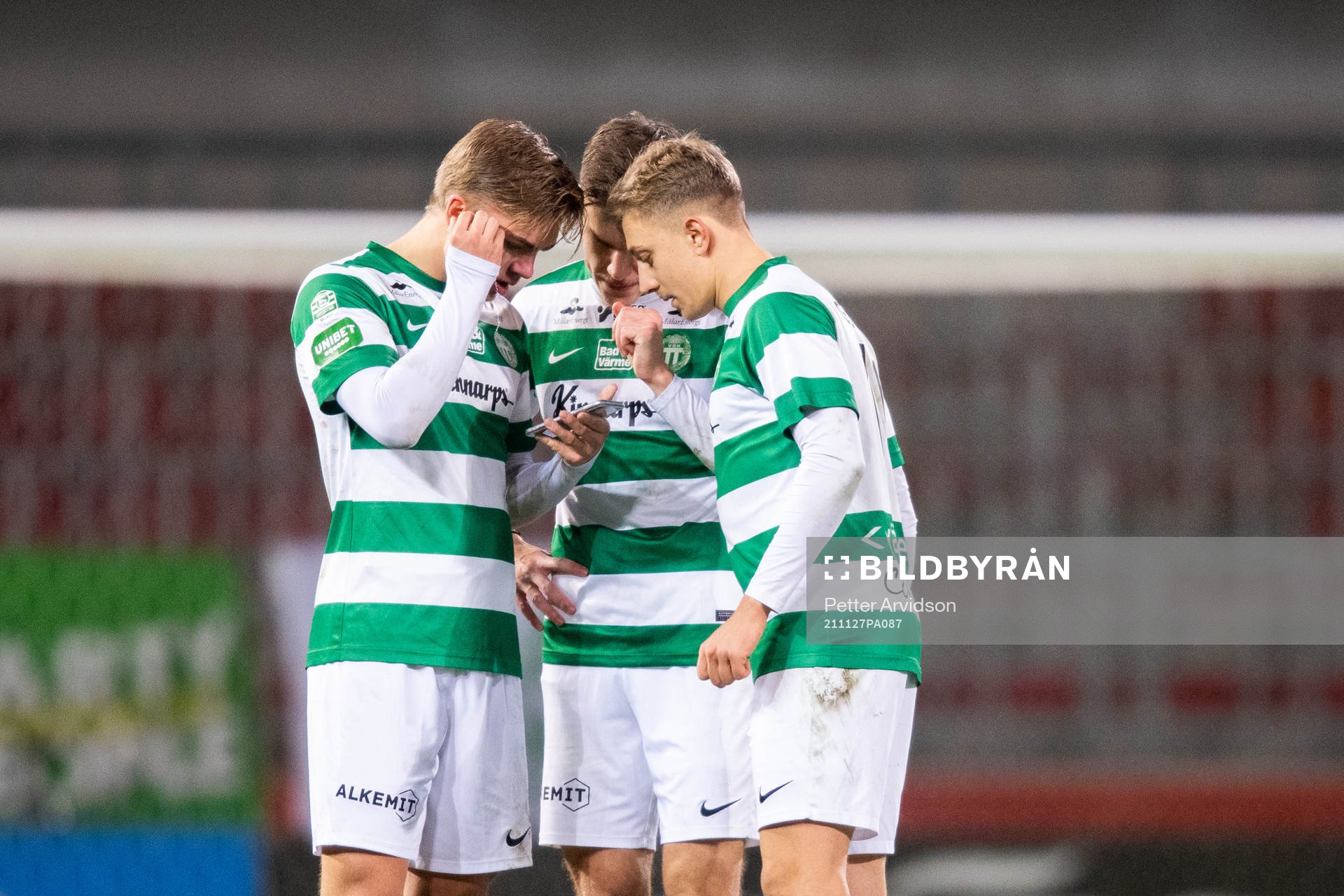 Västerås Dusan Jajic, Daniel Hermansson och Simon Gefvert följer slutet på en avgörande match på mobilen, Västerås undviker negativt kval till följ av det resultatet efter fotbollsmatchen i Superettan mellan Helsingborg och Västerås SK den 27 november 2021 i Helsingborg.