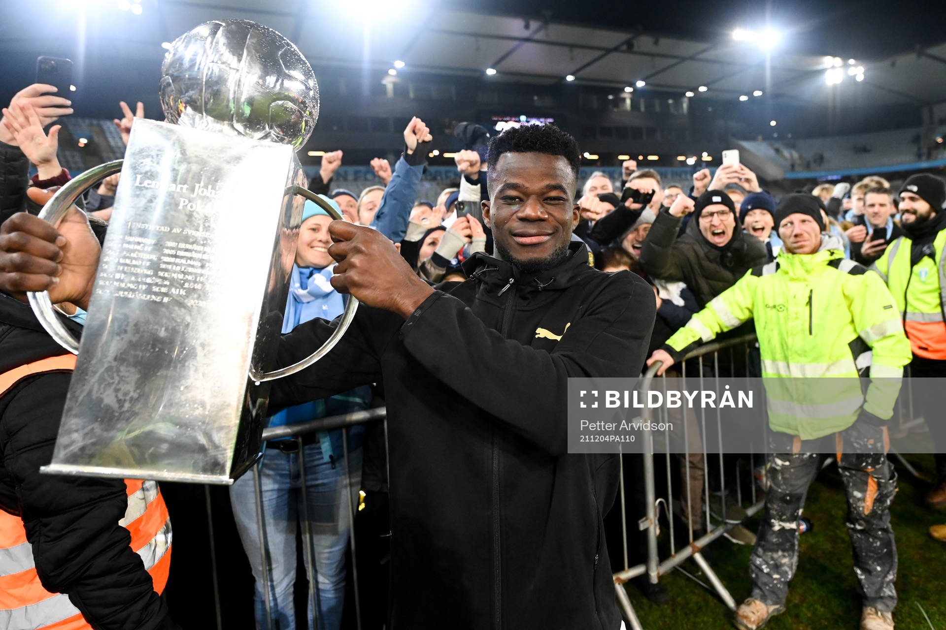 Malmö FFs Malik Abubakari jublar med pokalen efter fotbollsmatchen i Allsvenskan mellan Malmö FF och Halmstad den 4 december 2021 i Malmö.