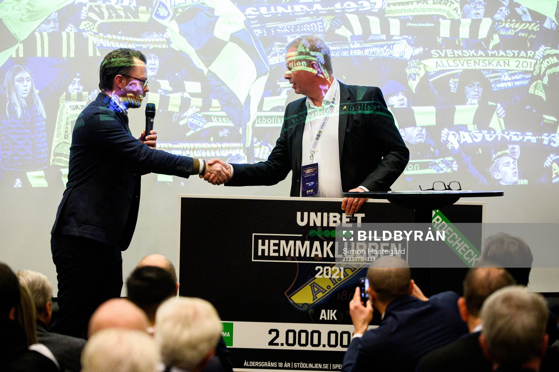 AIK Fotbolls ordförande Robert Falck tar emot en check