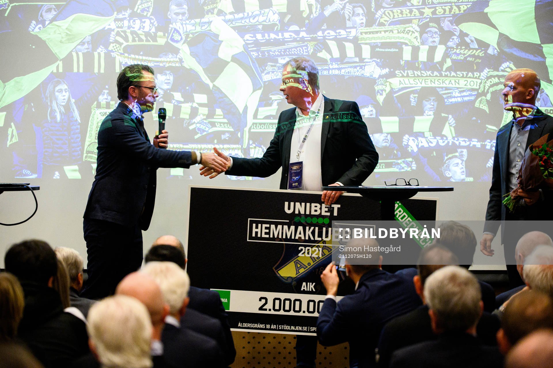 AIK Fotbolls ordförande Robert Falck tar emot en check