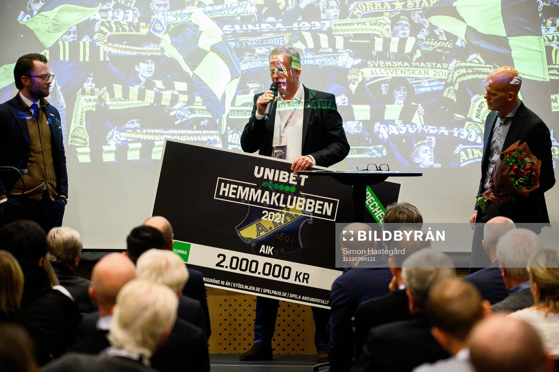 AIK Fotbolls ordförande Robert Falck tar emot en check