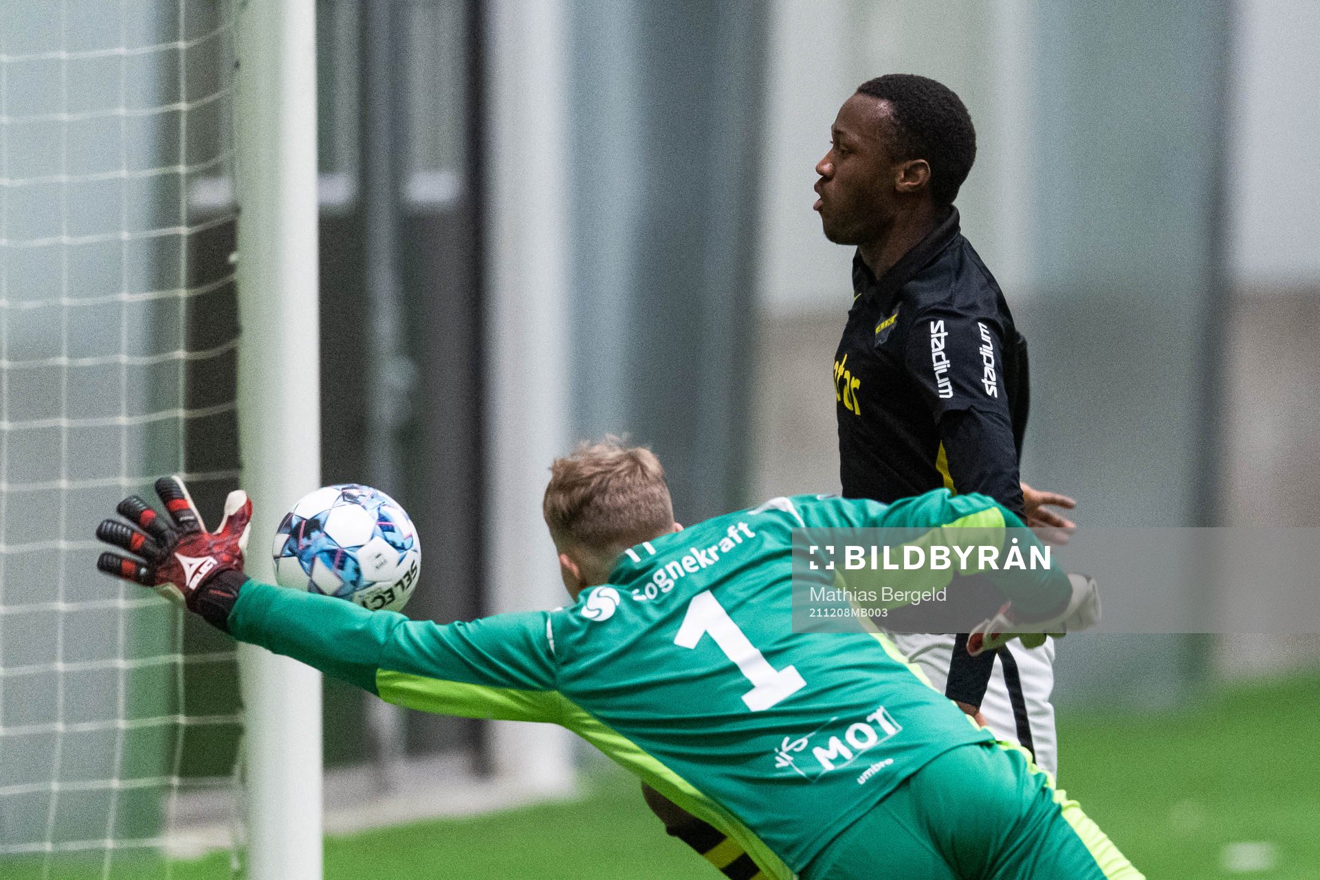 AIK:s Braxton Sserebe gör 0-1 bakom Sogndals målvakt Daniel Sætren under fotbollsmatchen i Skandinaviska Mästerskapen för P16 mellan Sogndal och AIK den 8 december 2021 i Borås.
