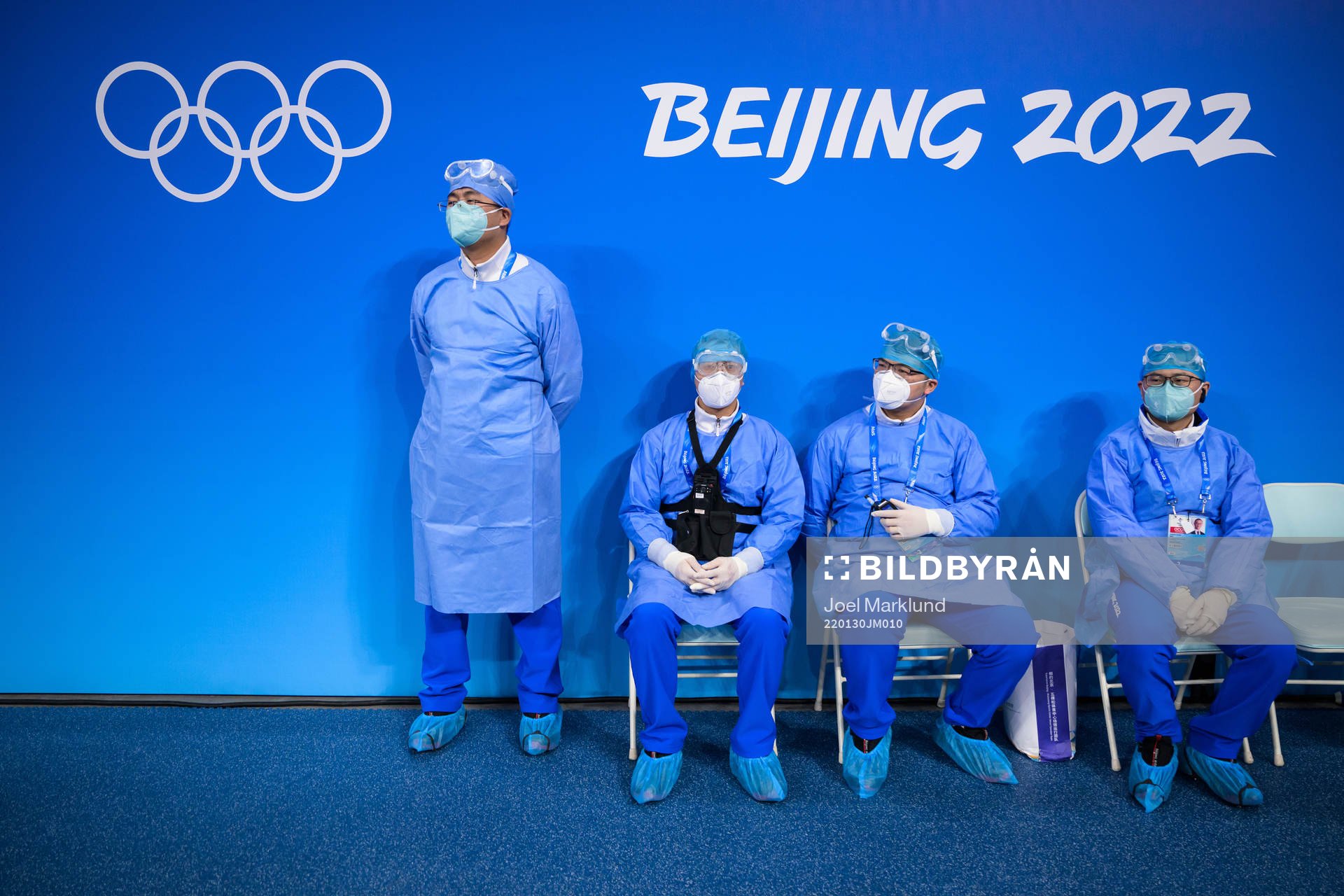 Medical personel in personal protective gear watch the