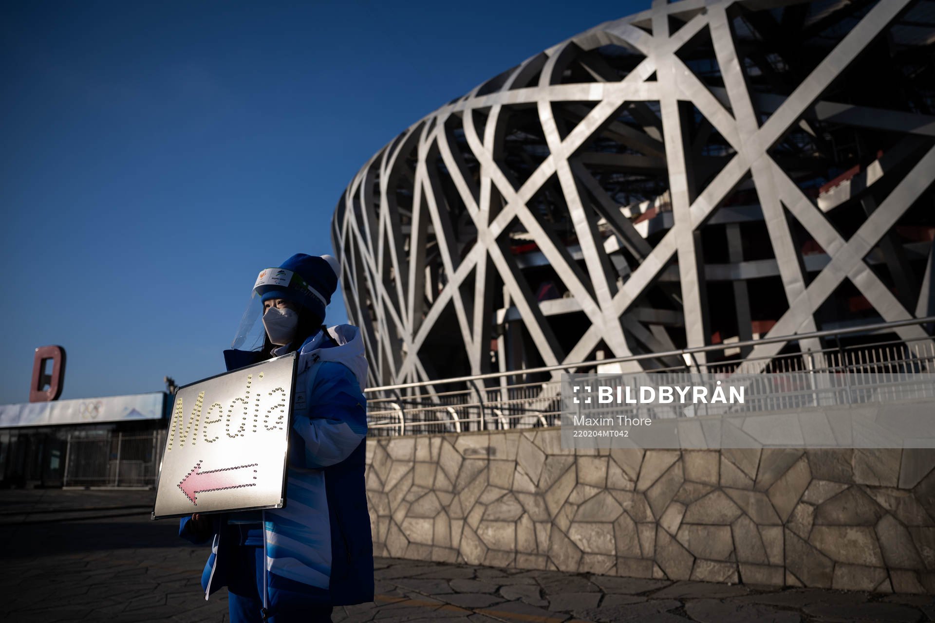 A volunteer in front of the National Stadium, also known as