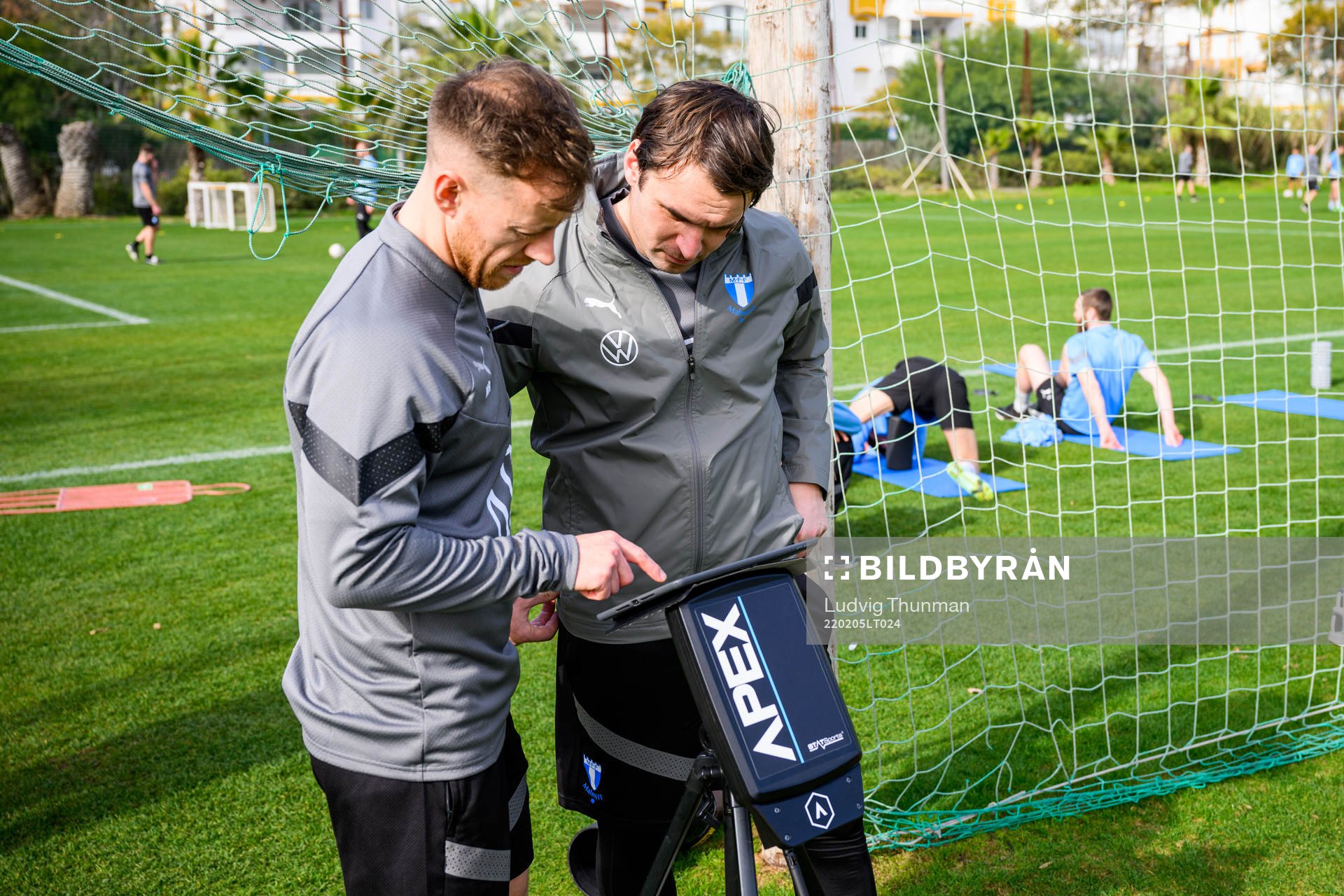 Fystränare Mark Read och tränare Milos Milojevic inspekterar en ipad som visar Apex systemet under en fotbollsträning med Malmö FF den 5 februari 2022 i Marbella.