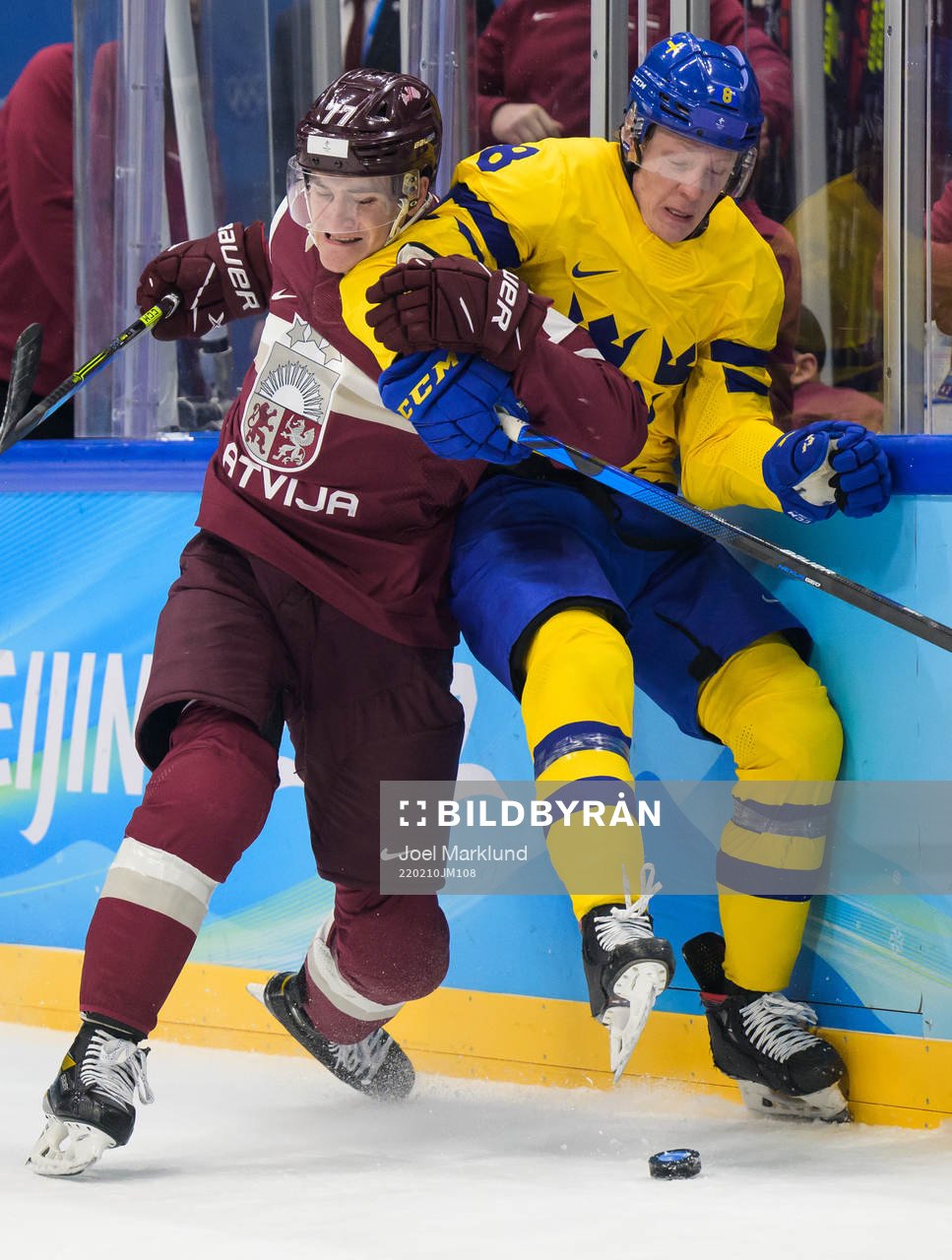 Kristaps Zile of Latvia tackles Fredrik Olofsson of Sweden