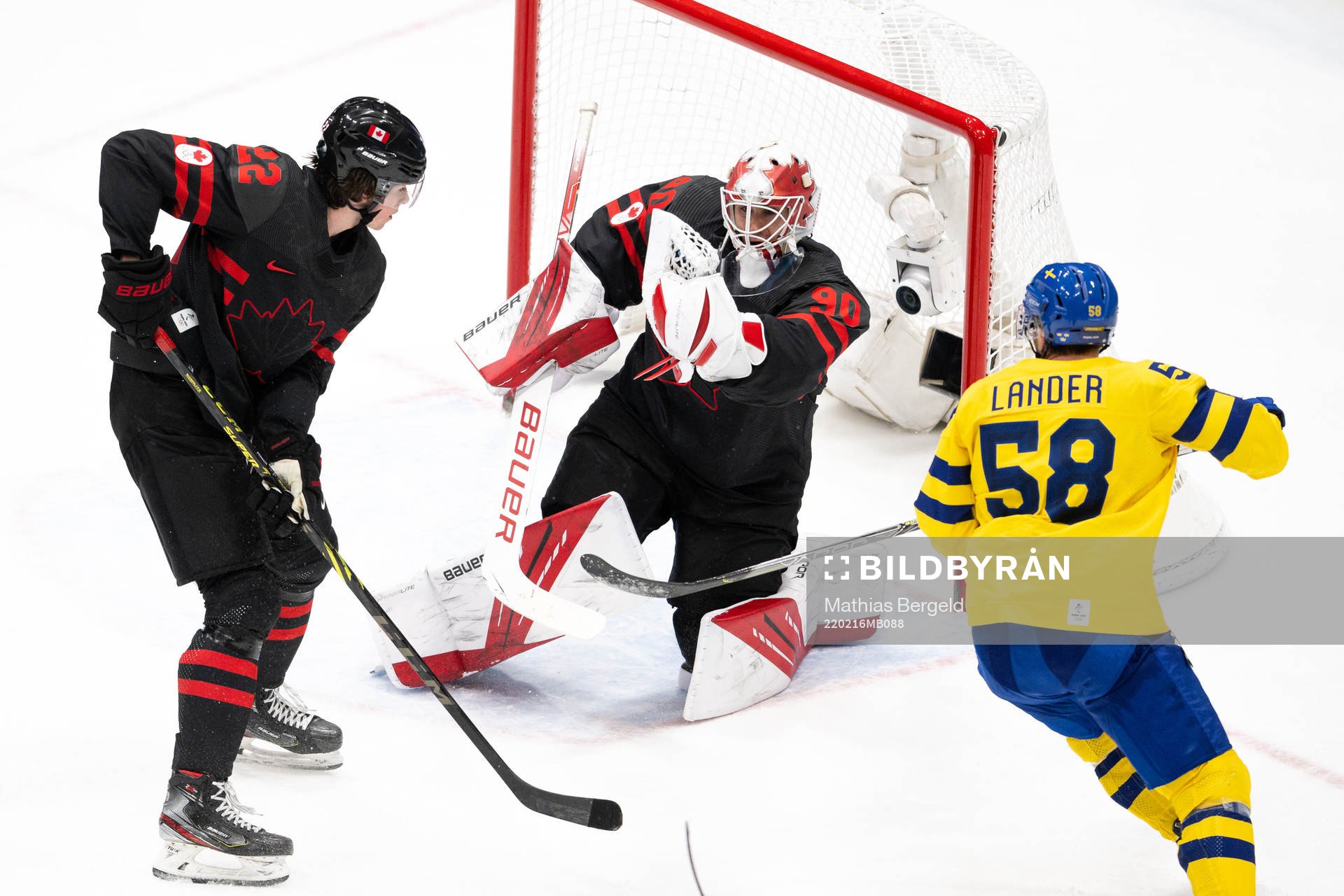 Anton Lander of Sweden against Owen Power and goaltender