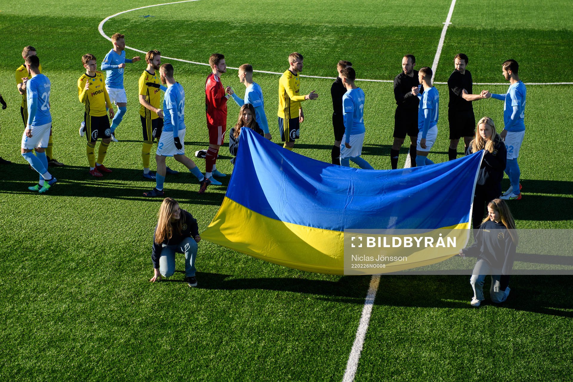 Funktionärer håller upp en Ukrainsk flagga