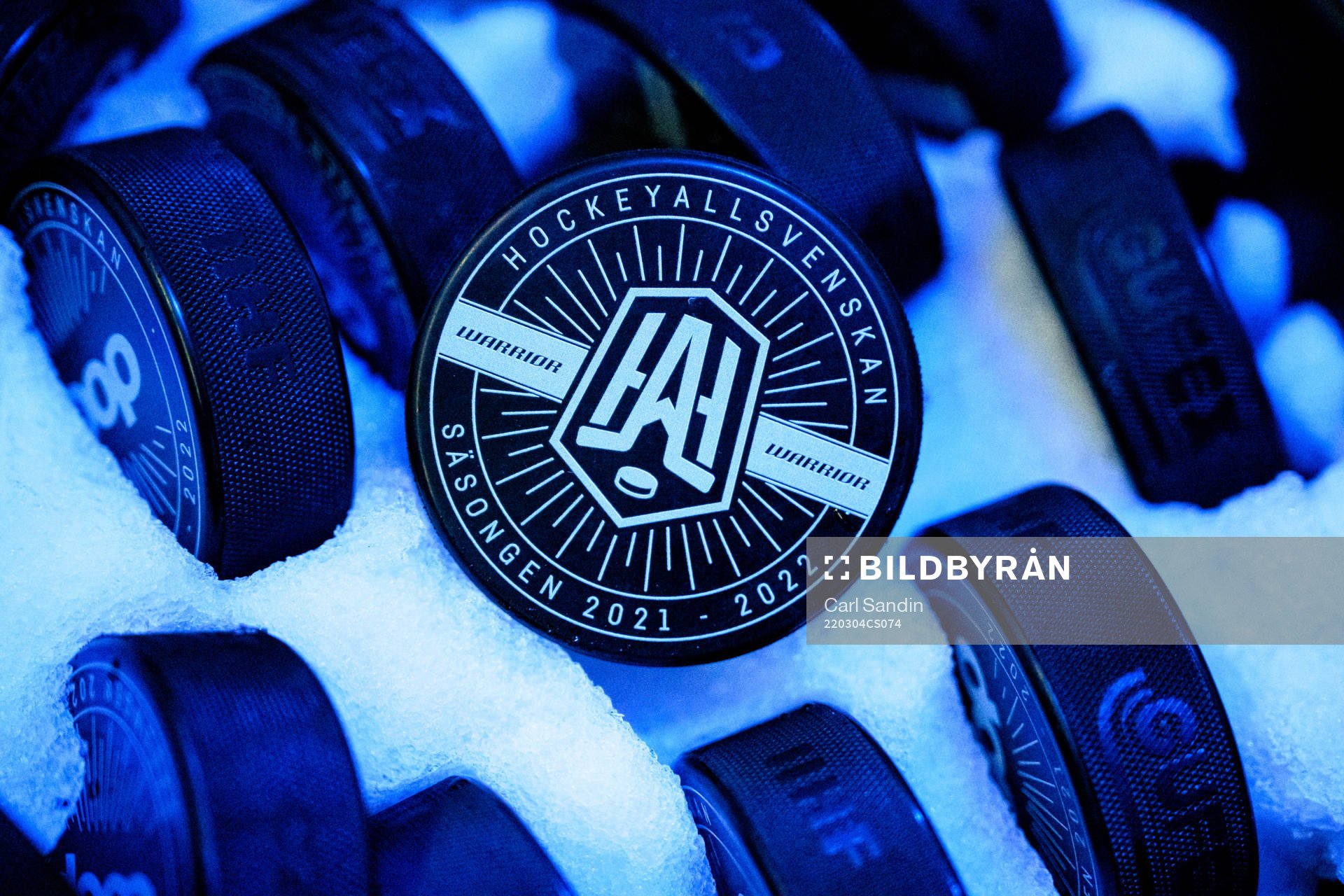 En puck med logotypen för Hockeyallsvenskan i en ishink