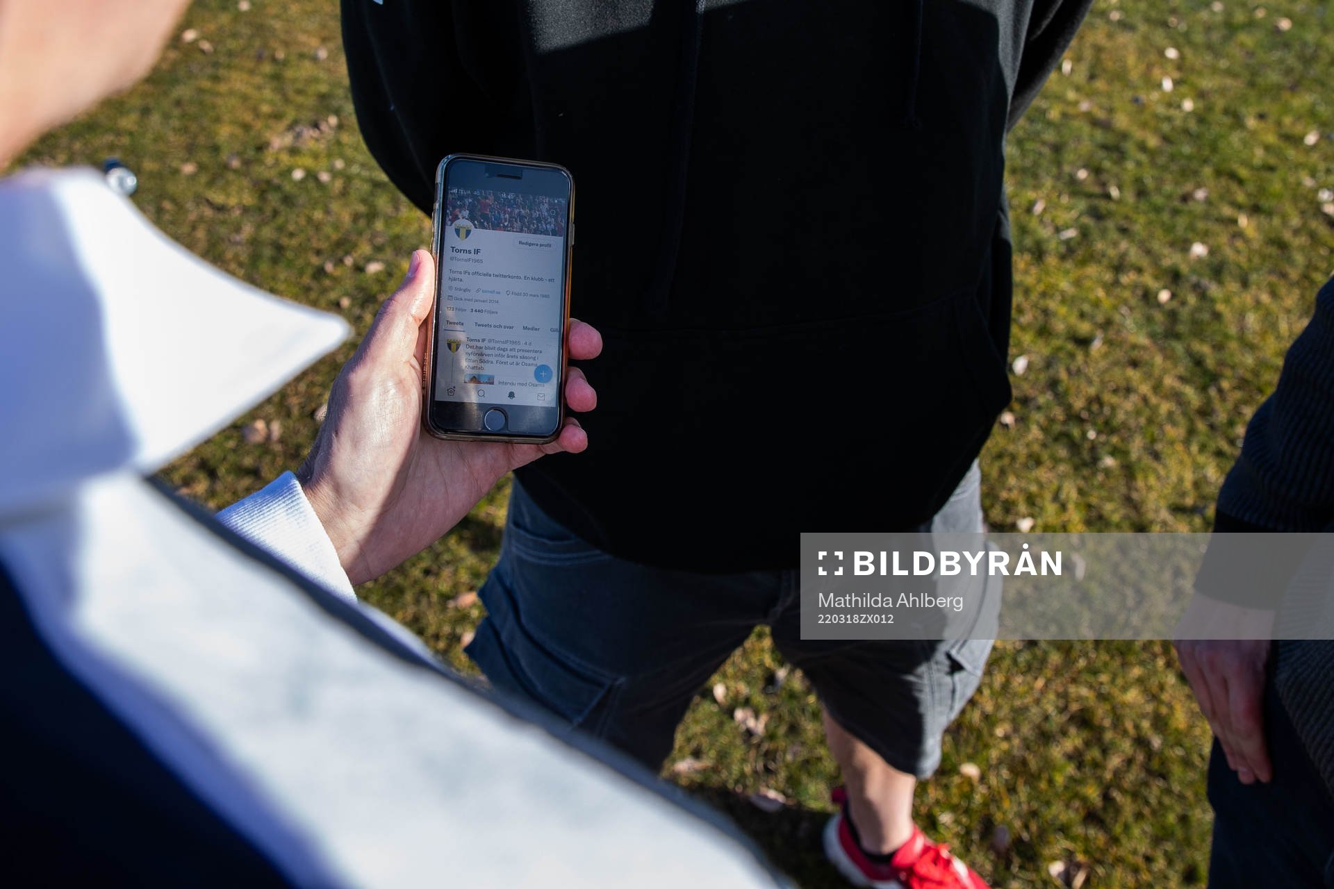 Tim Nielsen håller i en mobiltelefon med Torn IFs