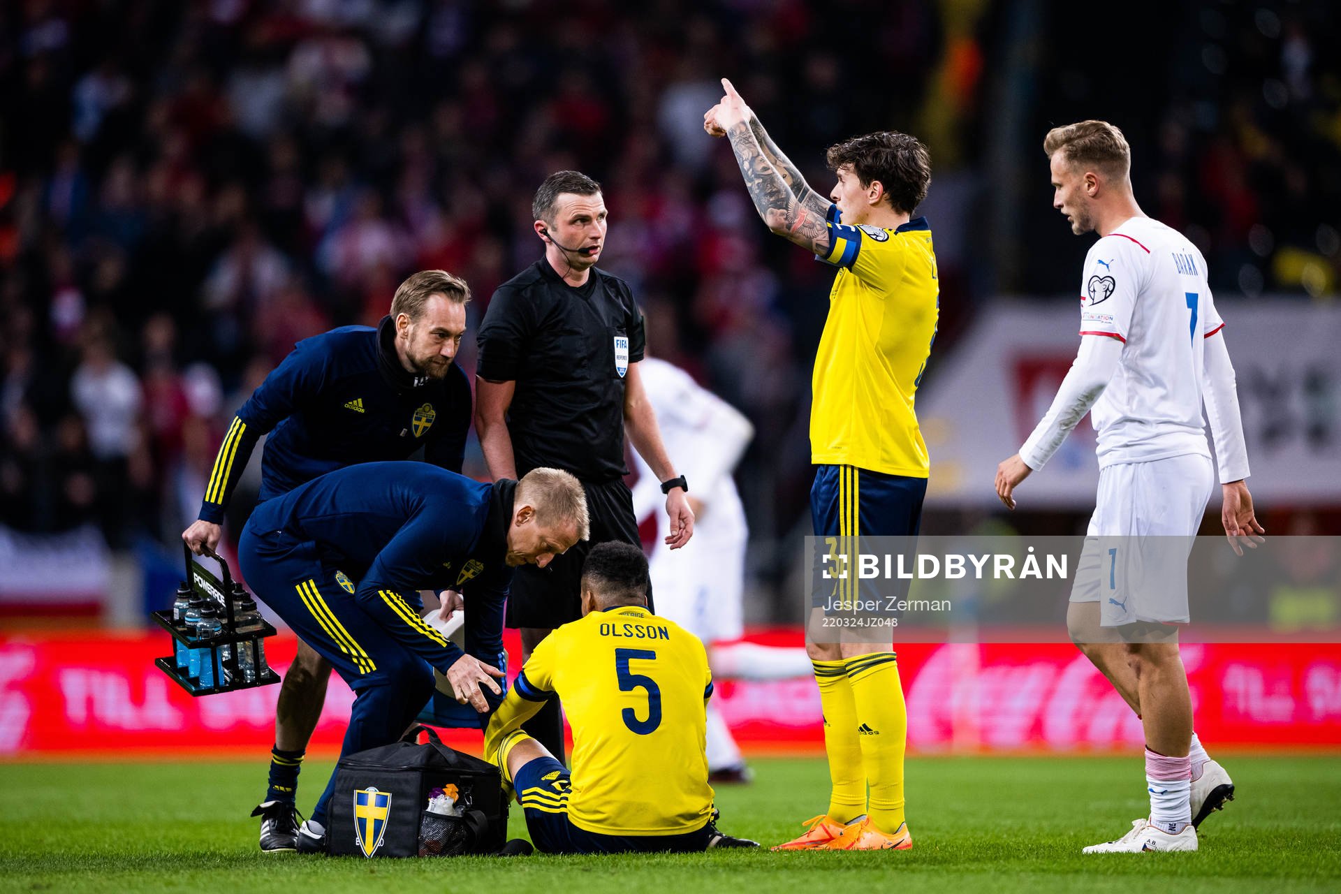Martin Olsson of Sweden in pain as Victor Lindelöf signals