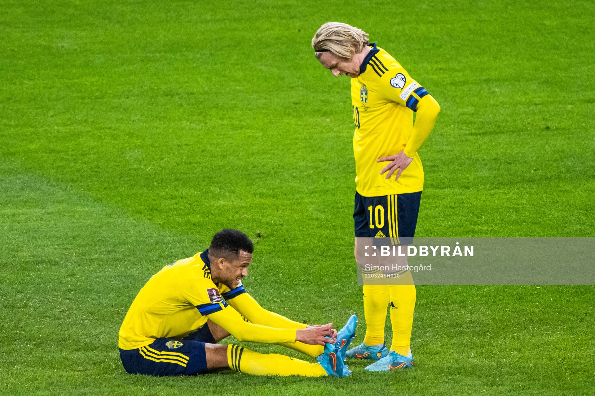 Martin Olsson of Sweden in pain next to Emil Forsberg