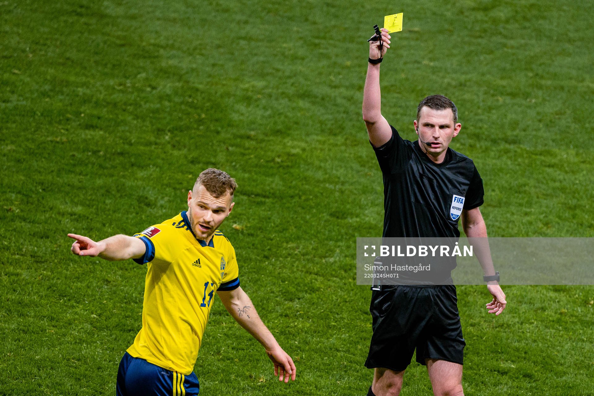 Jesper Karlström of Sweden receives a yellow card from