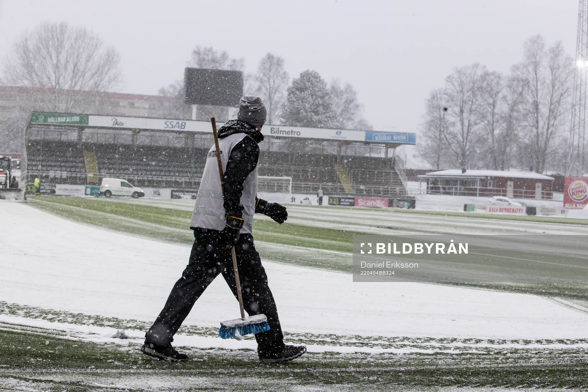 Funktionär sopar planen innan fotbollsmatchen i Superettan