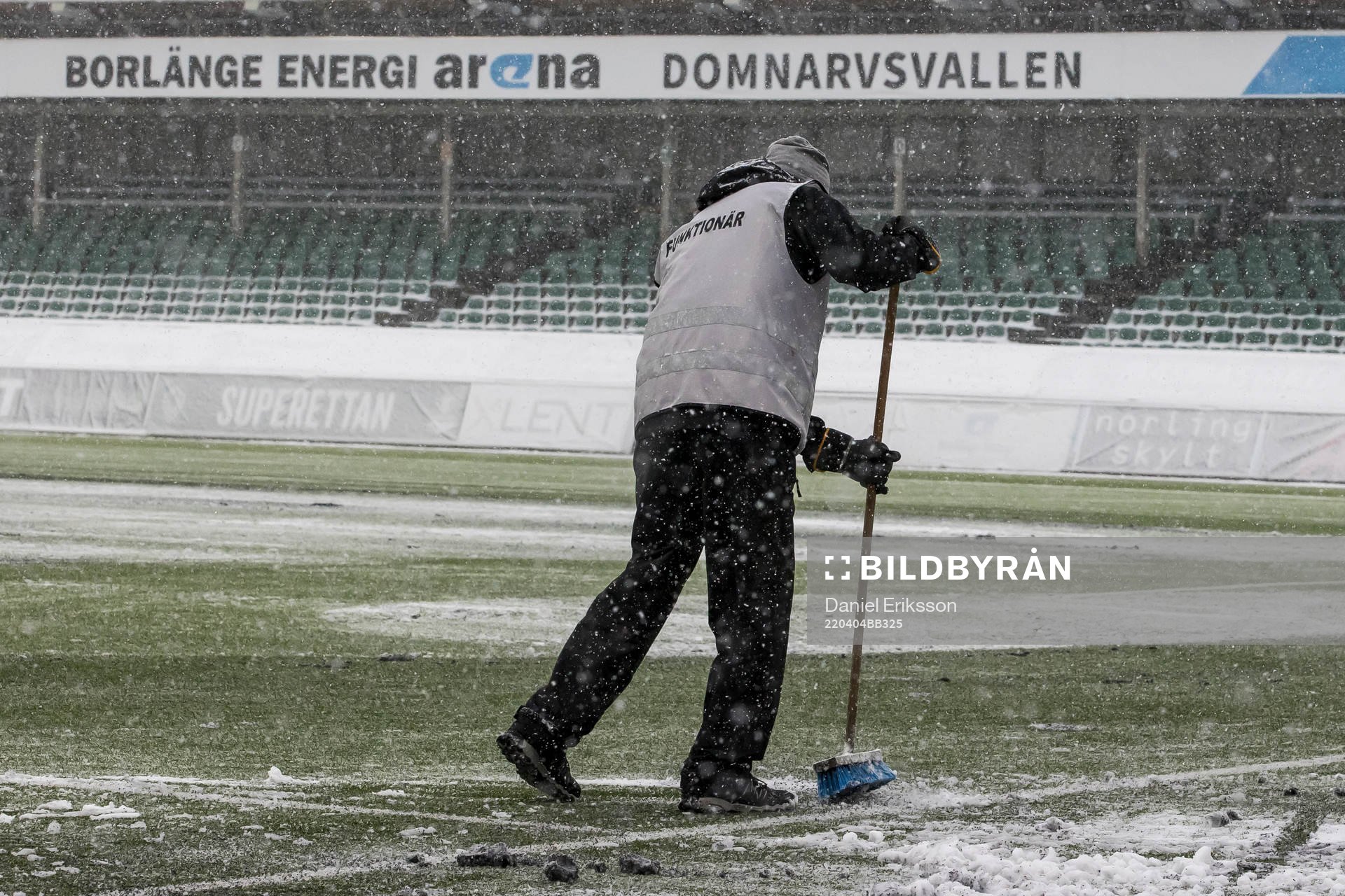 Funktionär sopar planen innan fotbollsmatchen i Superettan