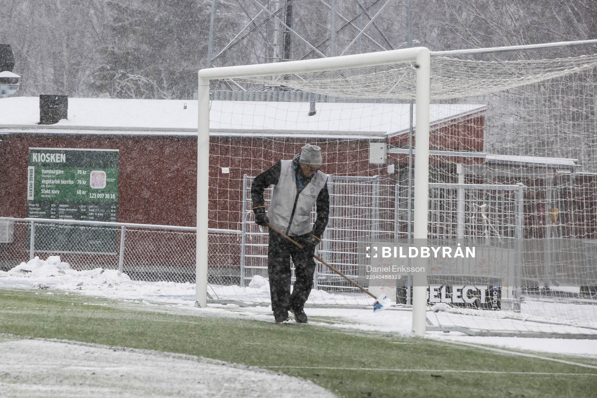 Funktionär sopar planen innan fotbollsmatchen i Superettan