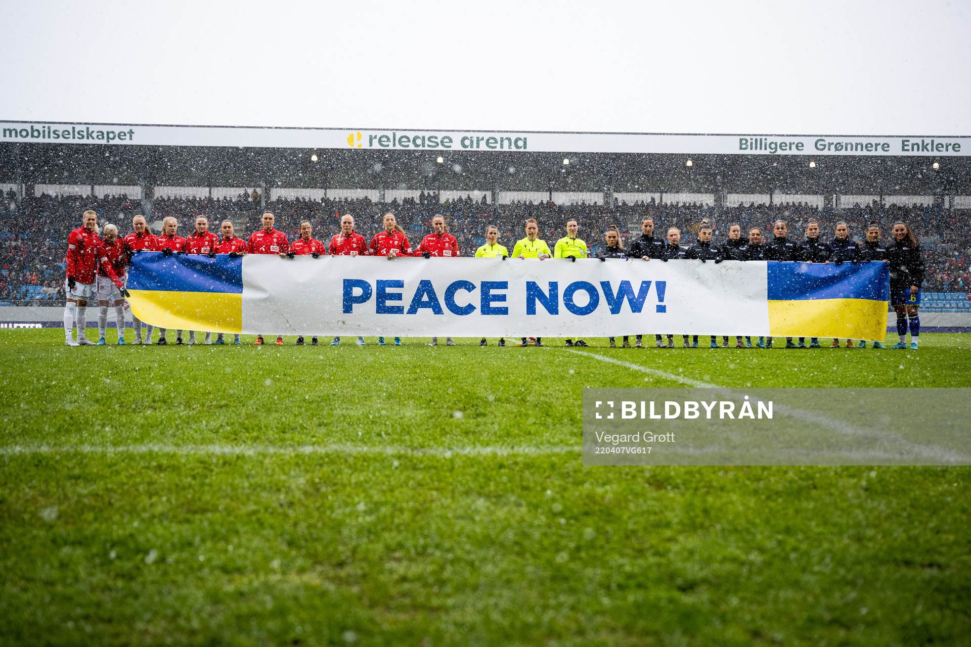 The players hold a «Peace Now!» sign