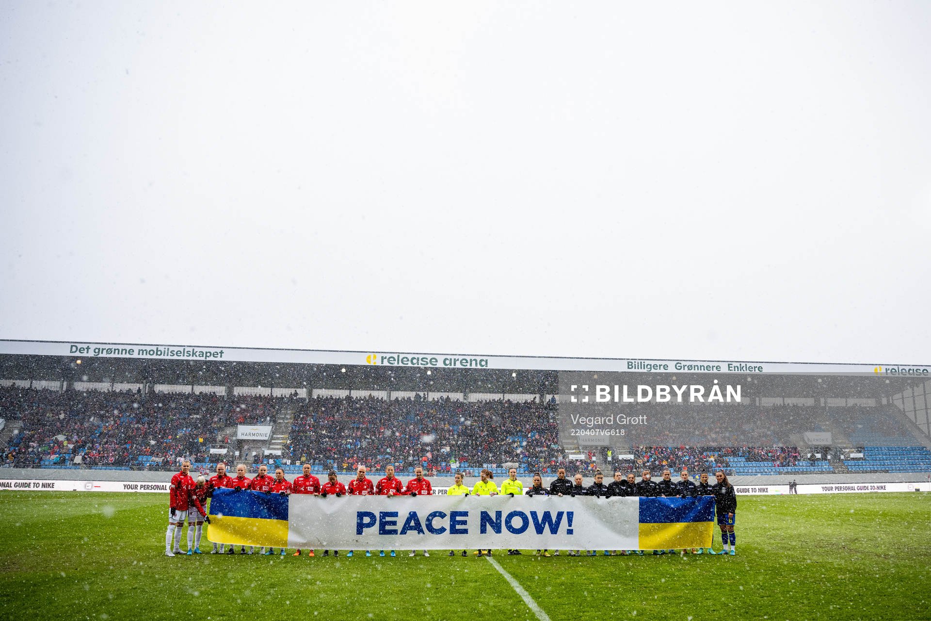 The players hold a «Peace Now!» sign