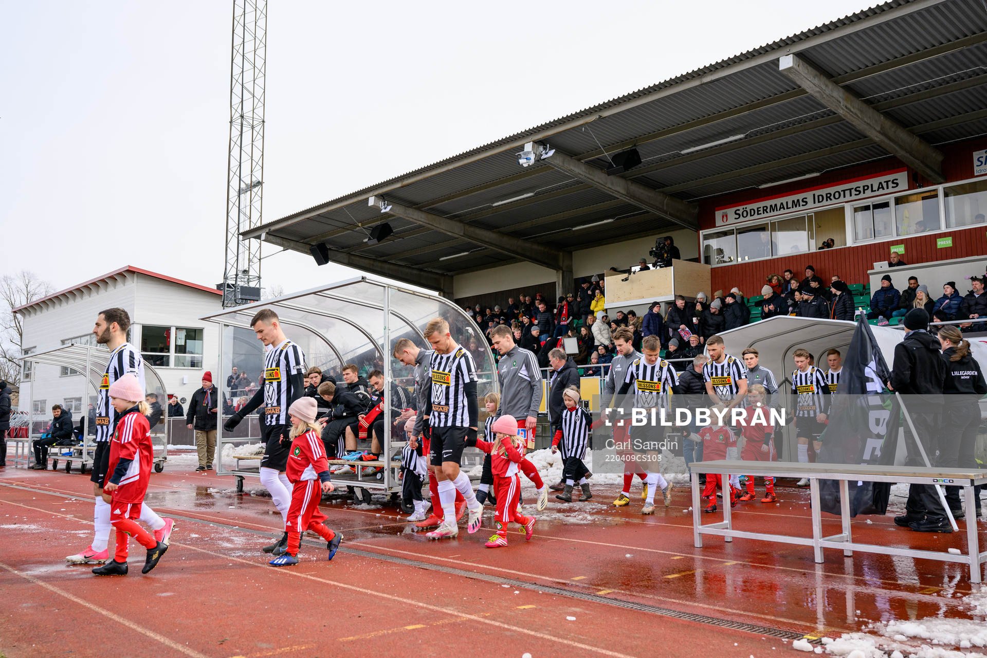 Spelarna går in på planen innan fotbollsmatchen i