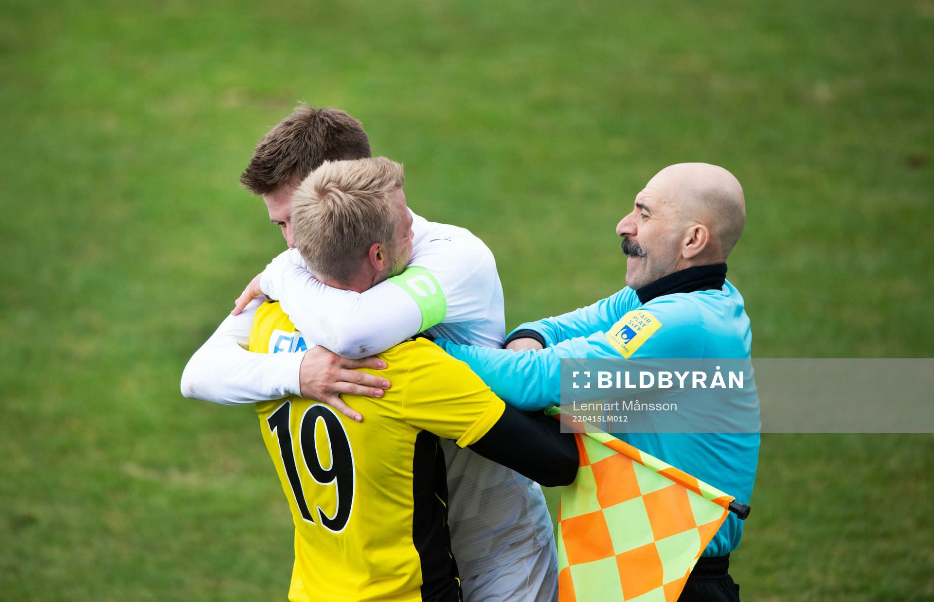 En Rosengårds-spelare kramar spontant om IFK Hässleholms Jens Lynard medan assisterande domaren försöker avvärja kramen i matchen i div. 2 Södra Götaland mellan IFK Hässleholm och FC Rosengård i Hässleholm 15 april 2022.