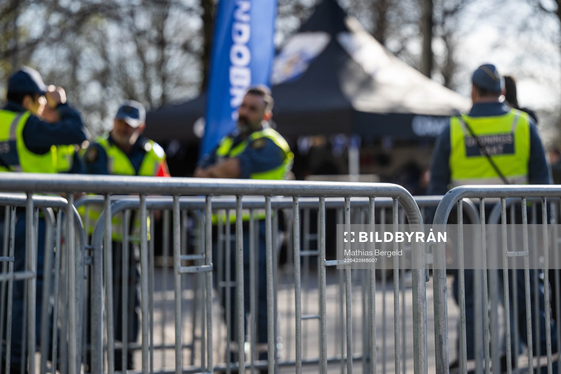 Vakter syns bakom ett kravallstaket vid entrén